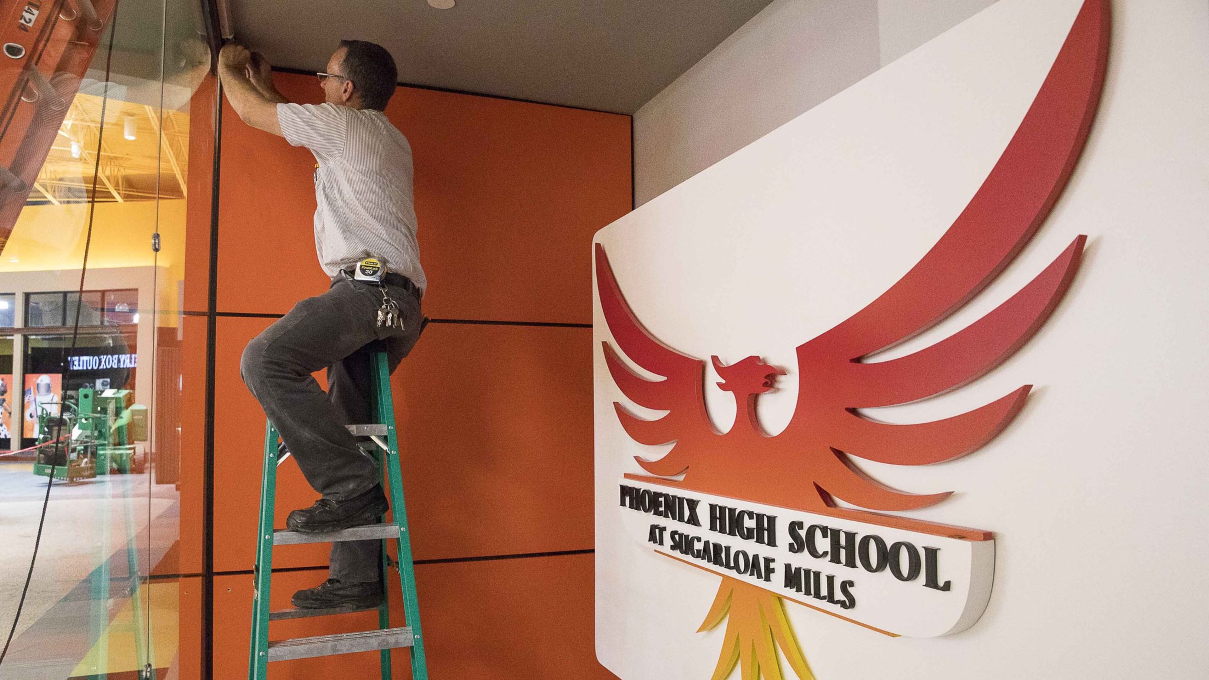 Maintenance work on an exterior sign continues at Phoenix High School at Sugarloaf Mills two days before the school’s dedication ceremony. Gwinnett County Schools will unveil Thursday, Oct. 18, a new branch of the Phoenix School, its alternative learning site. Most of the students are there because they run the risk of dropping out. The school will offer flexible class schedules and employment partnerships with mall merchants. Simon properties has tried this experiment at other locations and says it has had resounding success. ALYSSA POINTER / ALYSSA.POINTER@AJC.COM