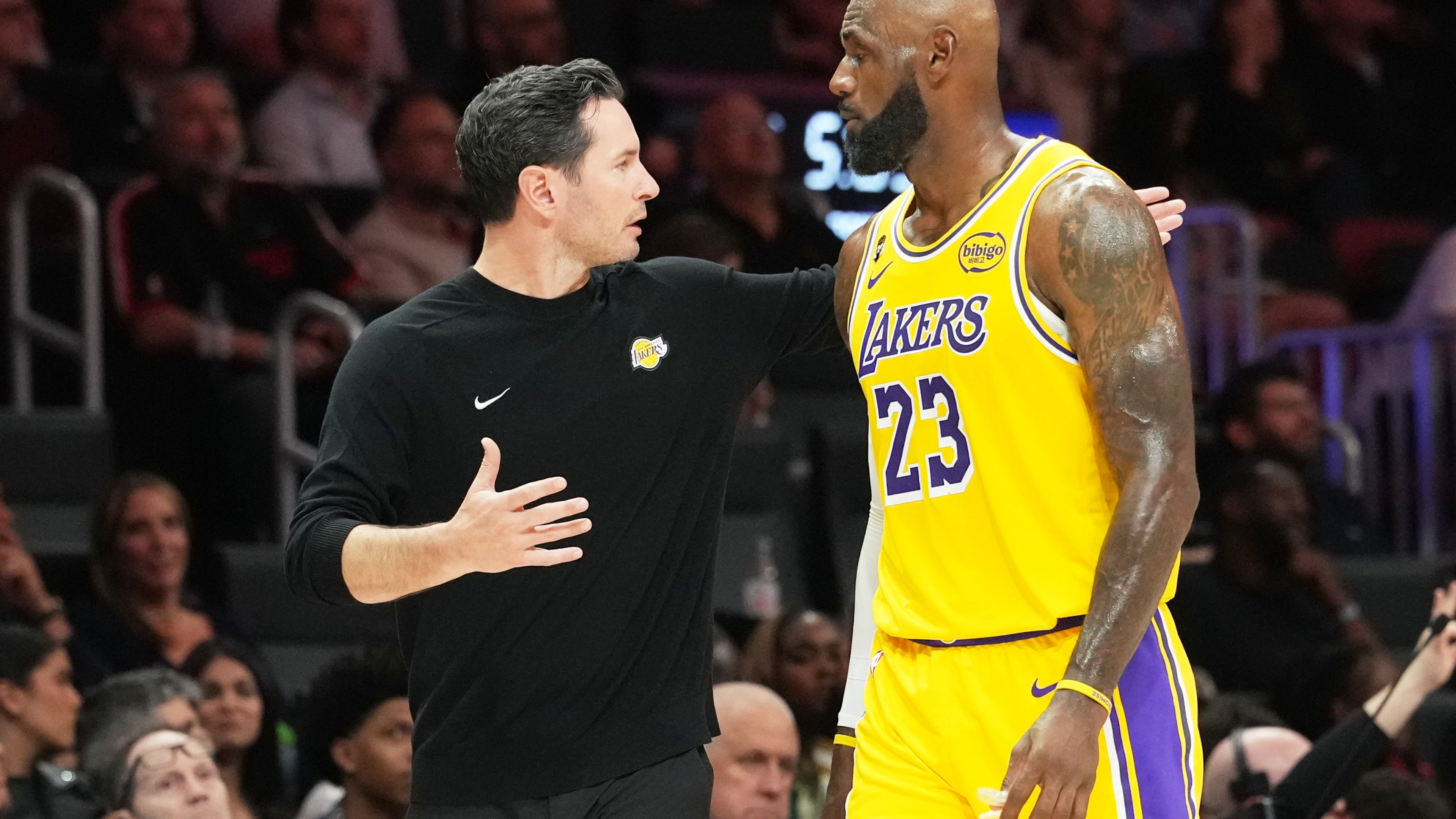 Los Angeles Lakers head coach JJ Redick, left, talks with forward LeBron James (23) during the second half of an NBA basketball game against the Miami Heat, Thursday, March 19, 2026, in Miami. (AP Photo/Lynne Sladky)
