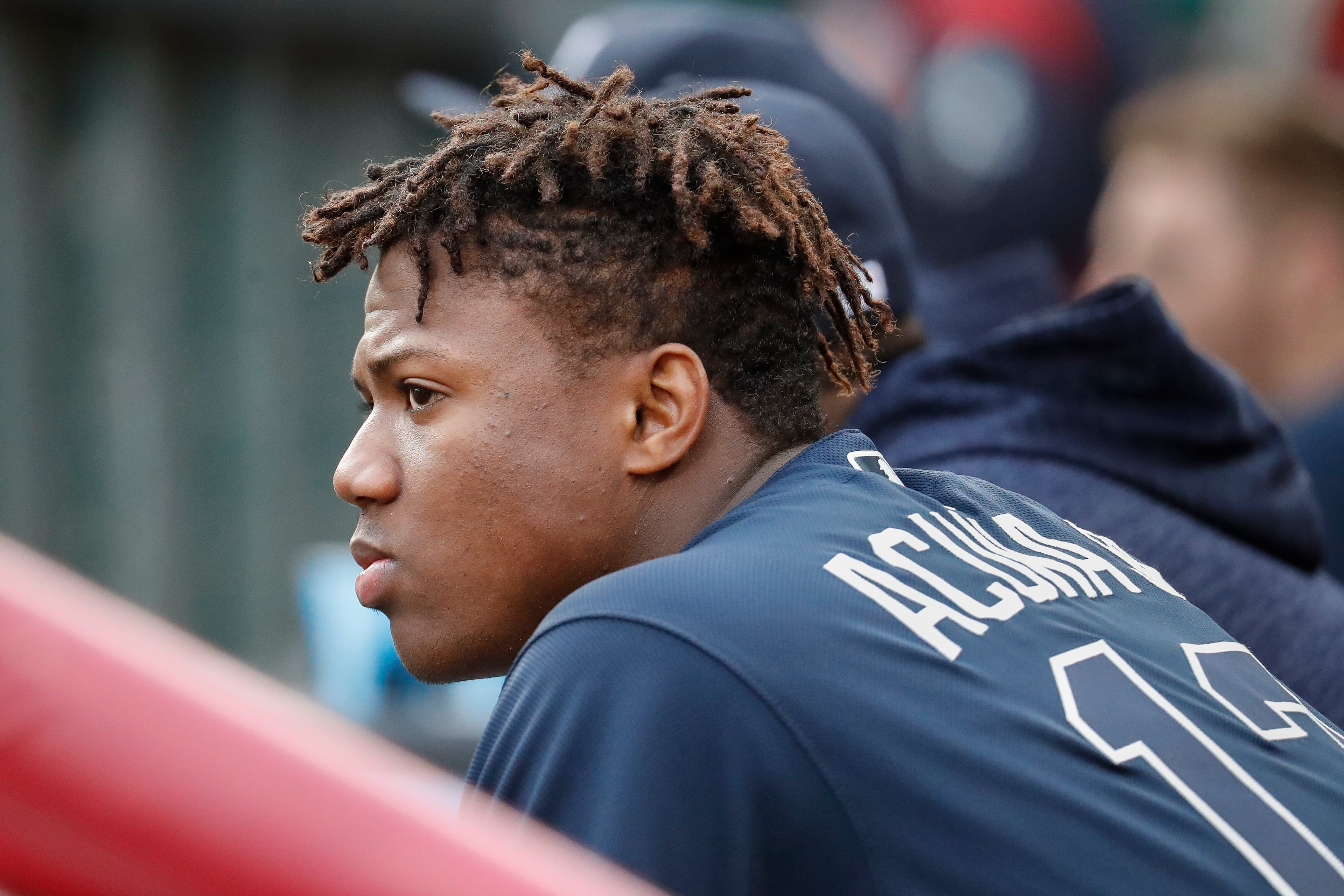 Atlanta Braves center fielder Ronald Acuna Jr. watches from the dugout during the second inning of the team's baseball game against the Cincinnati Reds, Wednesday, April 25, 2018, in Cincinnati. (AP Photo/John Minchillo)