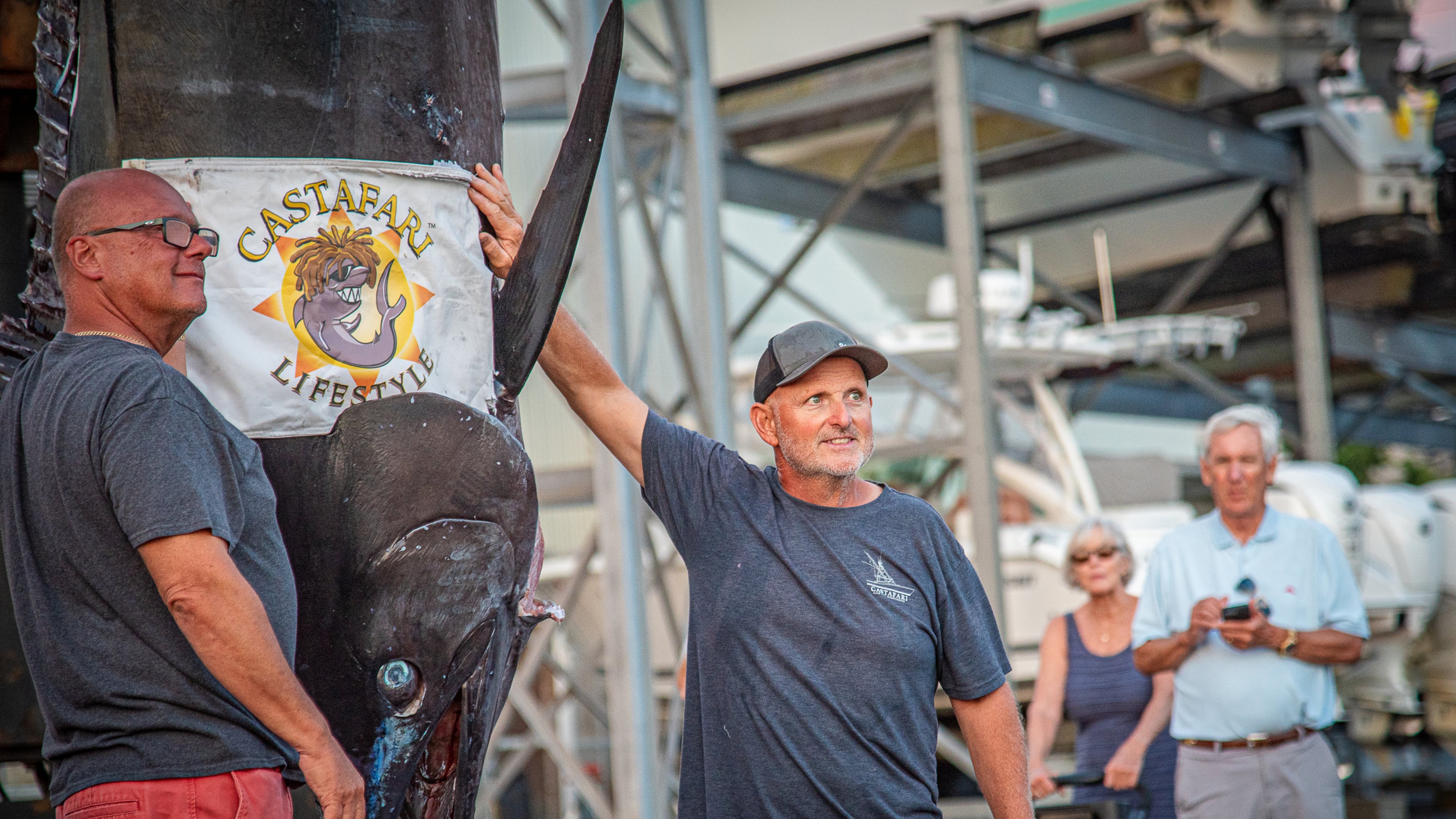 This photo provided by Jimmy Fee shows Walter Chapman, left, and Damon Sacco, captain of the Castafari, right, posing with an enormous blue marlin that they caught off the coast of Massachusetts, Wednesday, Aug. 19, 2026, in Falmouth, Mass. (Jimmy Fee via AP)