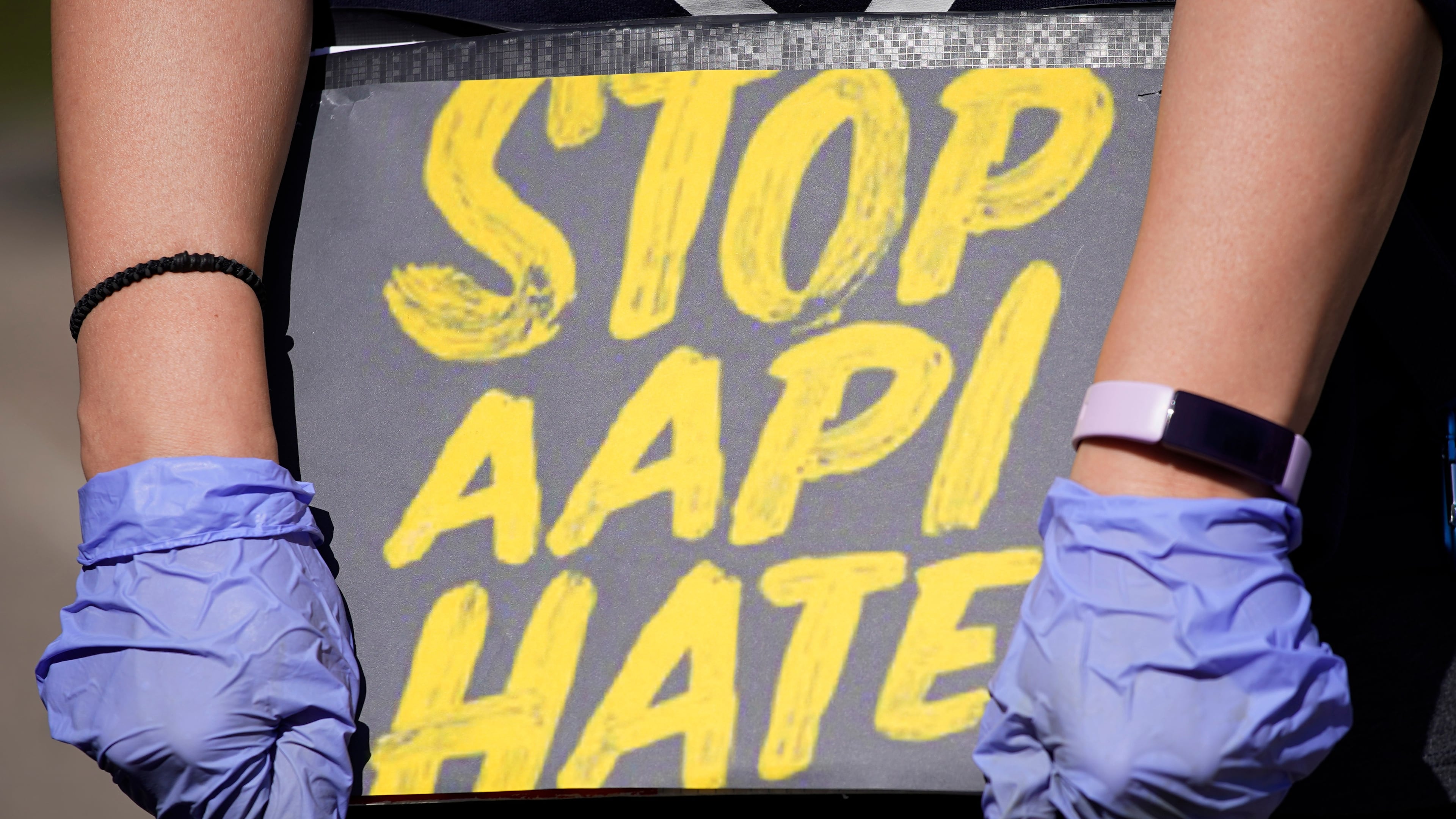 FILE - A person holds a sign and attends a rally to support Stop AAPI (Asian Americans and Pacific Islanders) Hate at the Logan Square Monument in Chicago, March 20, 2021. (AP Photo/Nam Y. Huh, File)