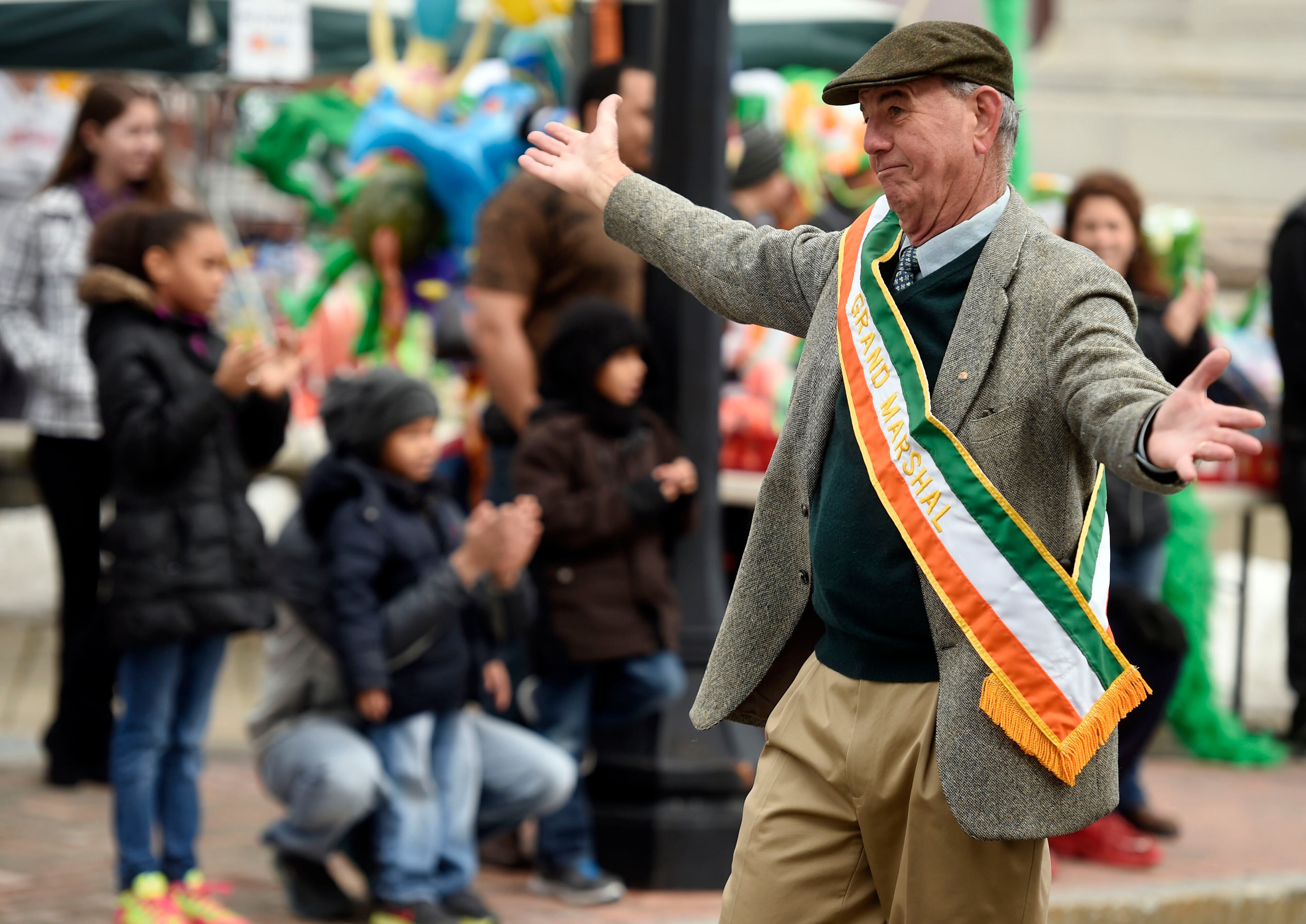 Grand Marshal Fran DePeter shrugs as he is introduced from the reviewing stand to the crowd as he marches from Bank Street onto State Street in the New London, Conn., St. Patrick's Day Parade on March 15, 2015.