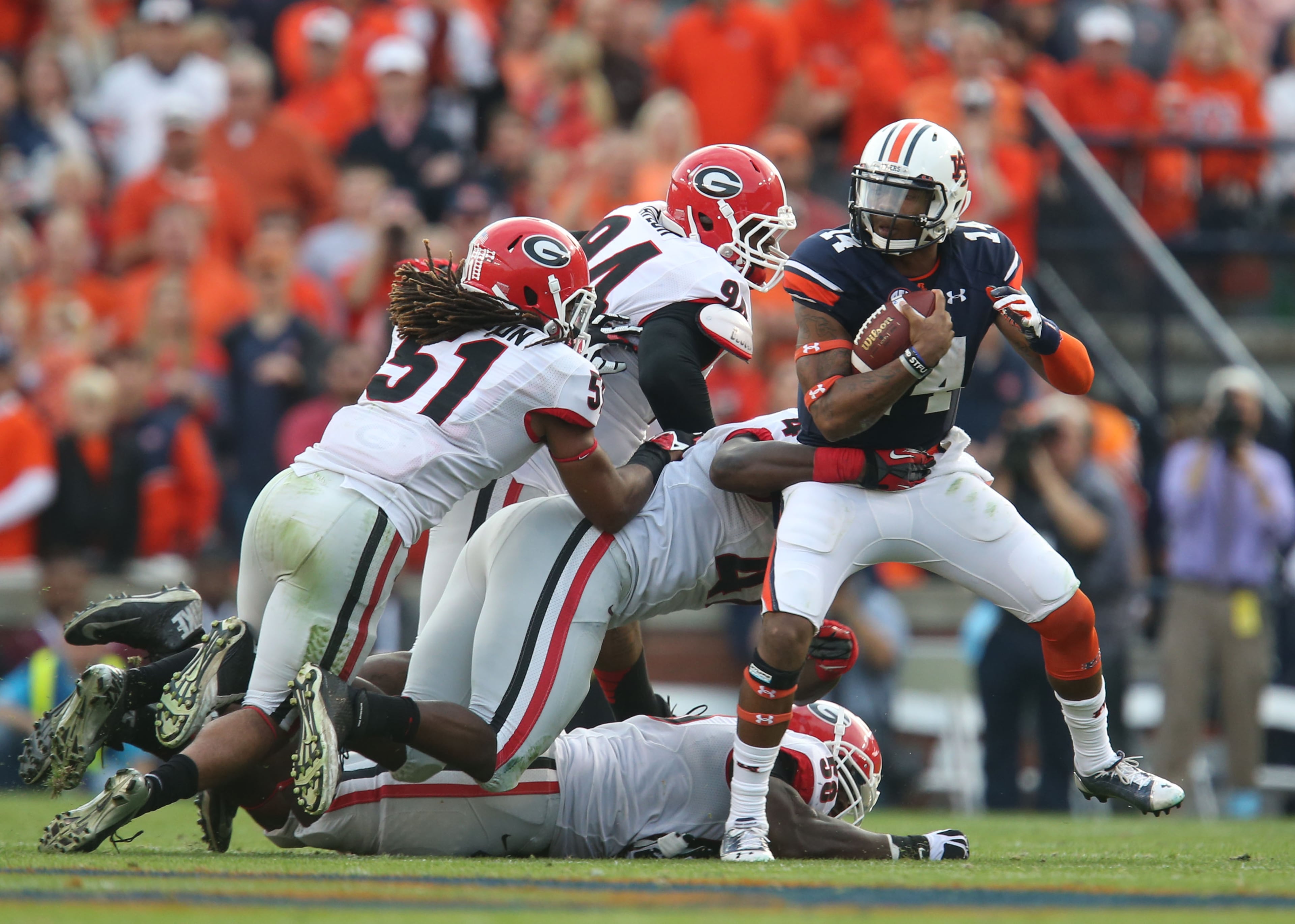 (1 of 5) Auburn Tigers quarterback Nick Marshall (14) is able to get out of the tackle of Georgia Bulldogs linebacker Ramik Wilson (51), defensive ends John Taylor (94), Ray Drew (47) and Sterling Bailey (58) for a first down run in the first half of their game at Jordan-Hare Stadium Saturday afternoon in Auburn, Al., November 16, 2013.