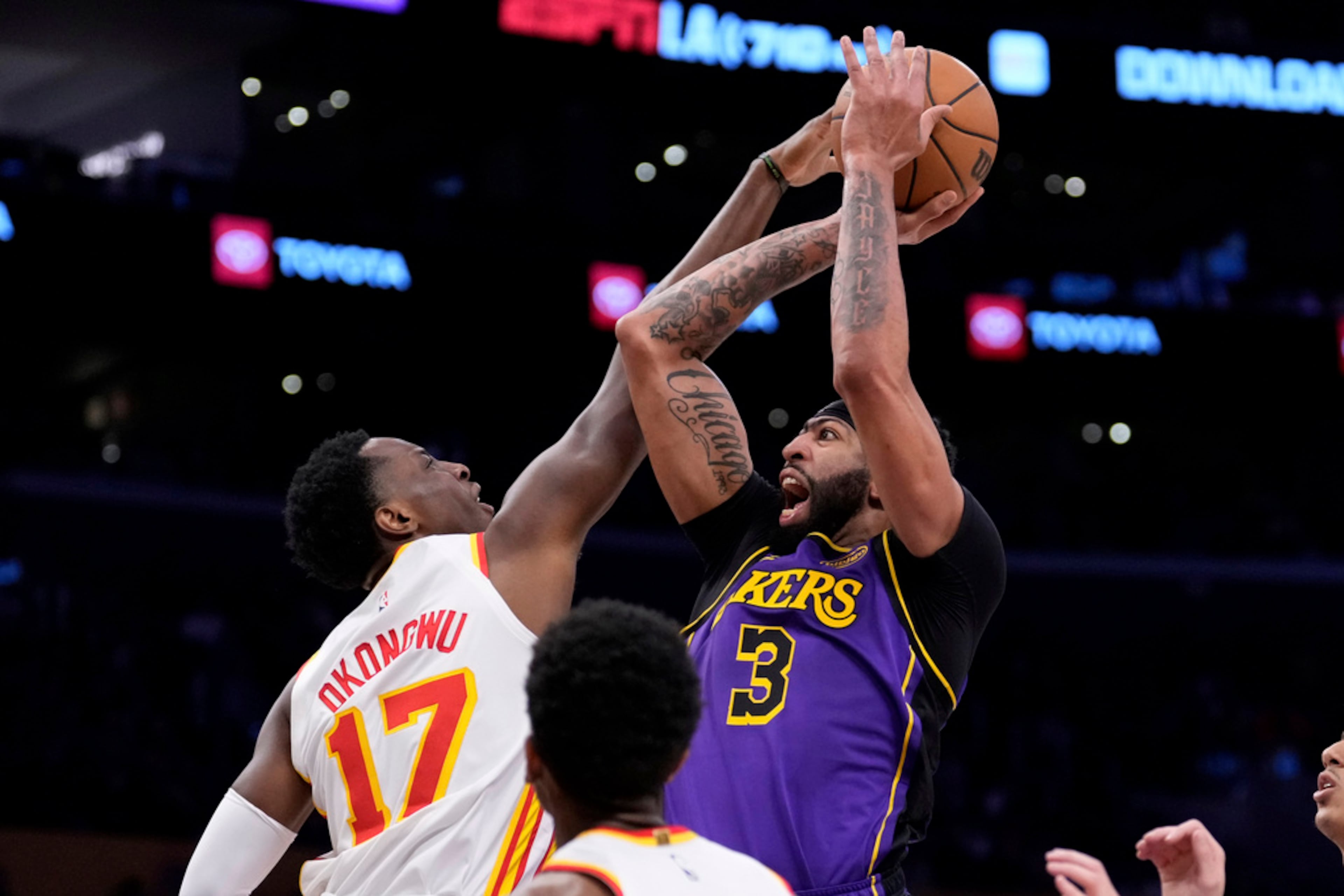 Los Angeles Lakers forward Anthony Davis, right, shoots as Atlanta Hawks forward Onyeka Okongwu defends during the first half of an NBA basketball game, Friday, Jan. 3, 2025, in Los Angeles. (AP Photo/Mark J. Terrill)