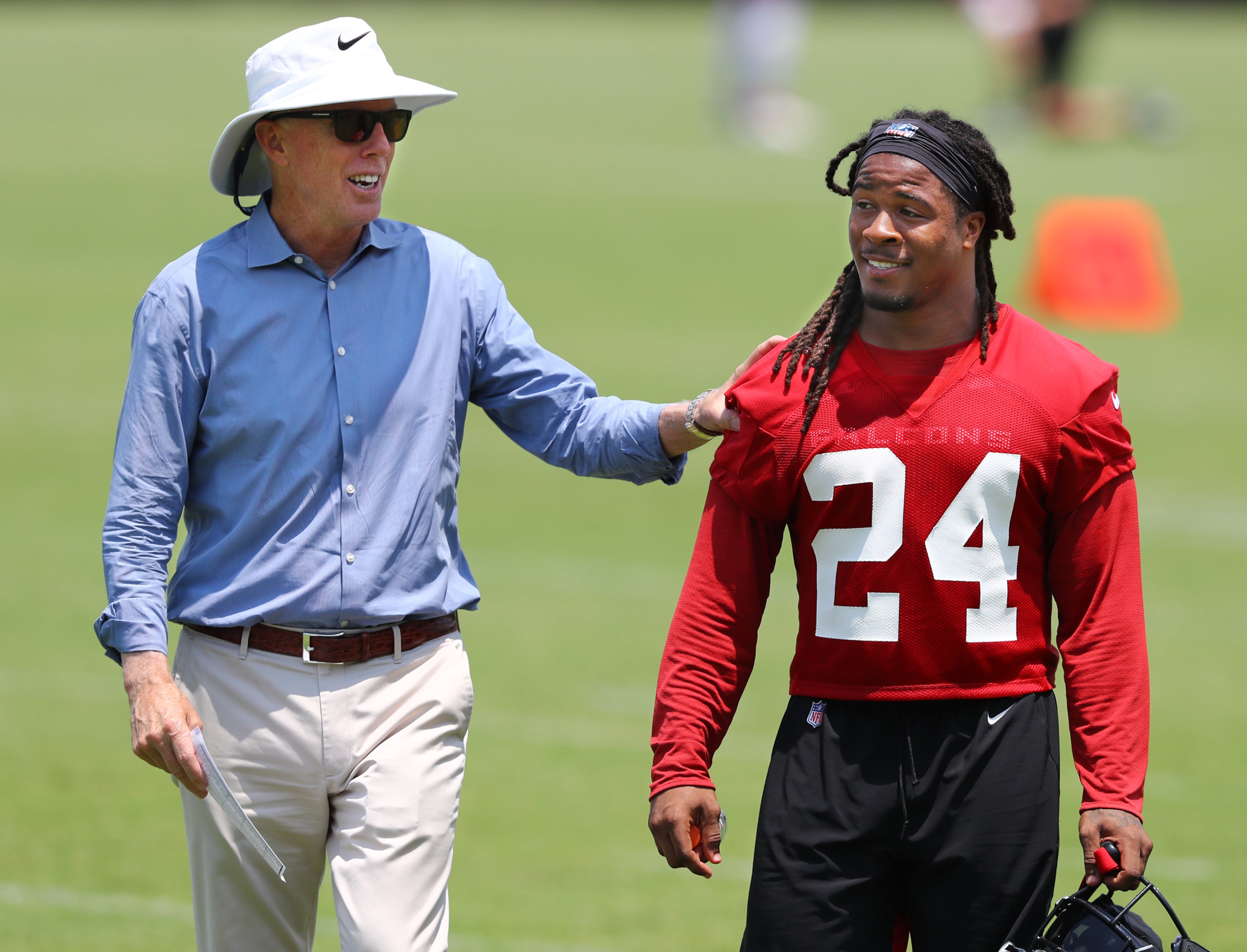 Falcons President and CEO Rich McKay gives running back Devonta Freeman a pat on the back. Curtis Compton/ccompton@ajc.com