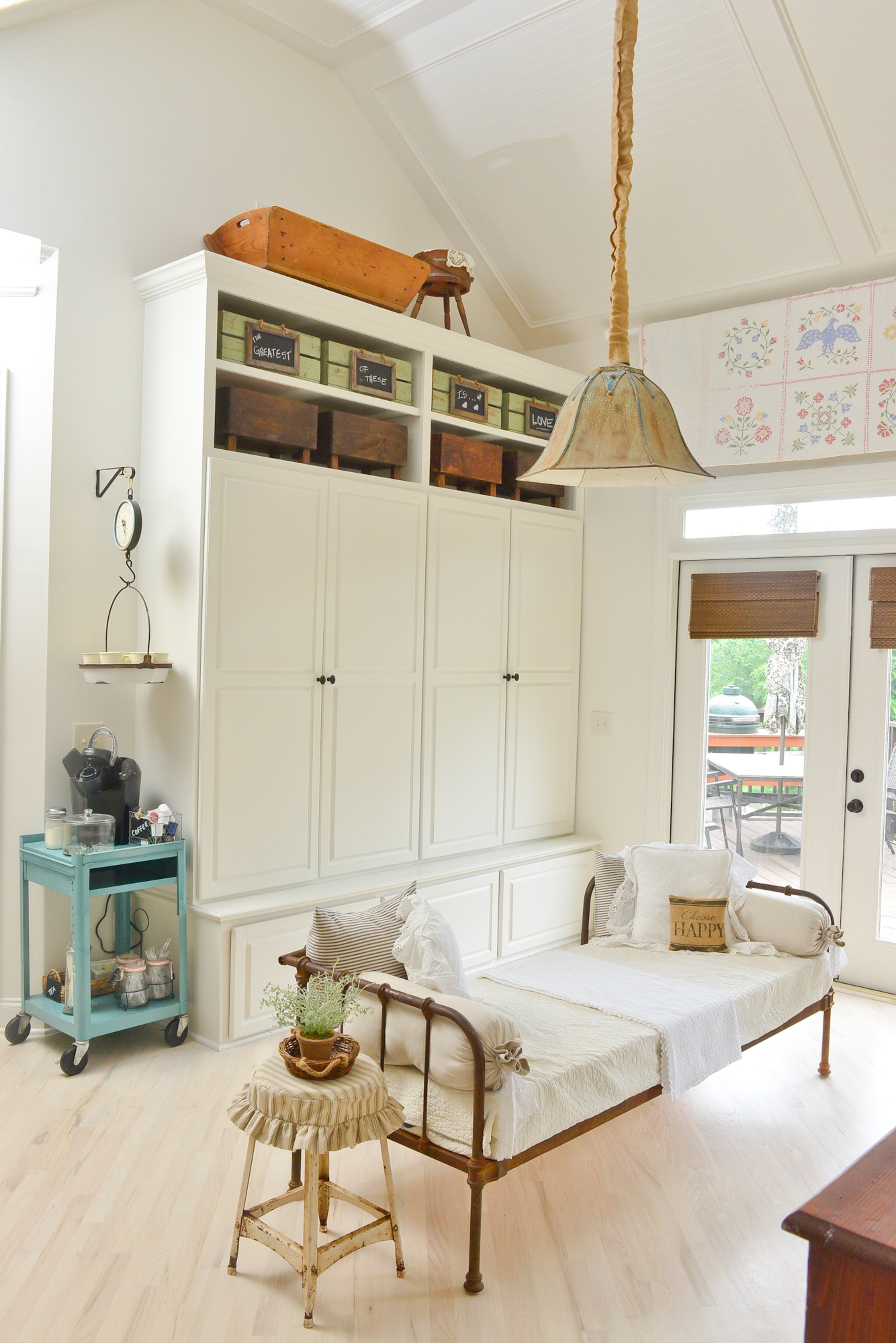 In one corner of the keeping room, the homeowner has hung a vintage kitchen scale above a blue hospital cart. The scale holds cups, and the cart is used as a drinks station when the family entertains guests. Over the backdoor is another of Wendy Durnwald's grandmother's quilts. The pantry is custom cabinetry by Mike Brehl of HID Construction.
