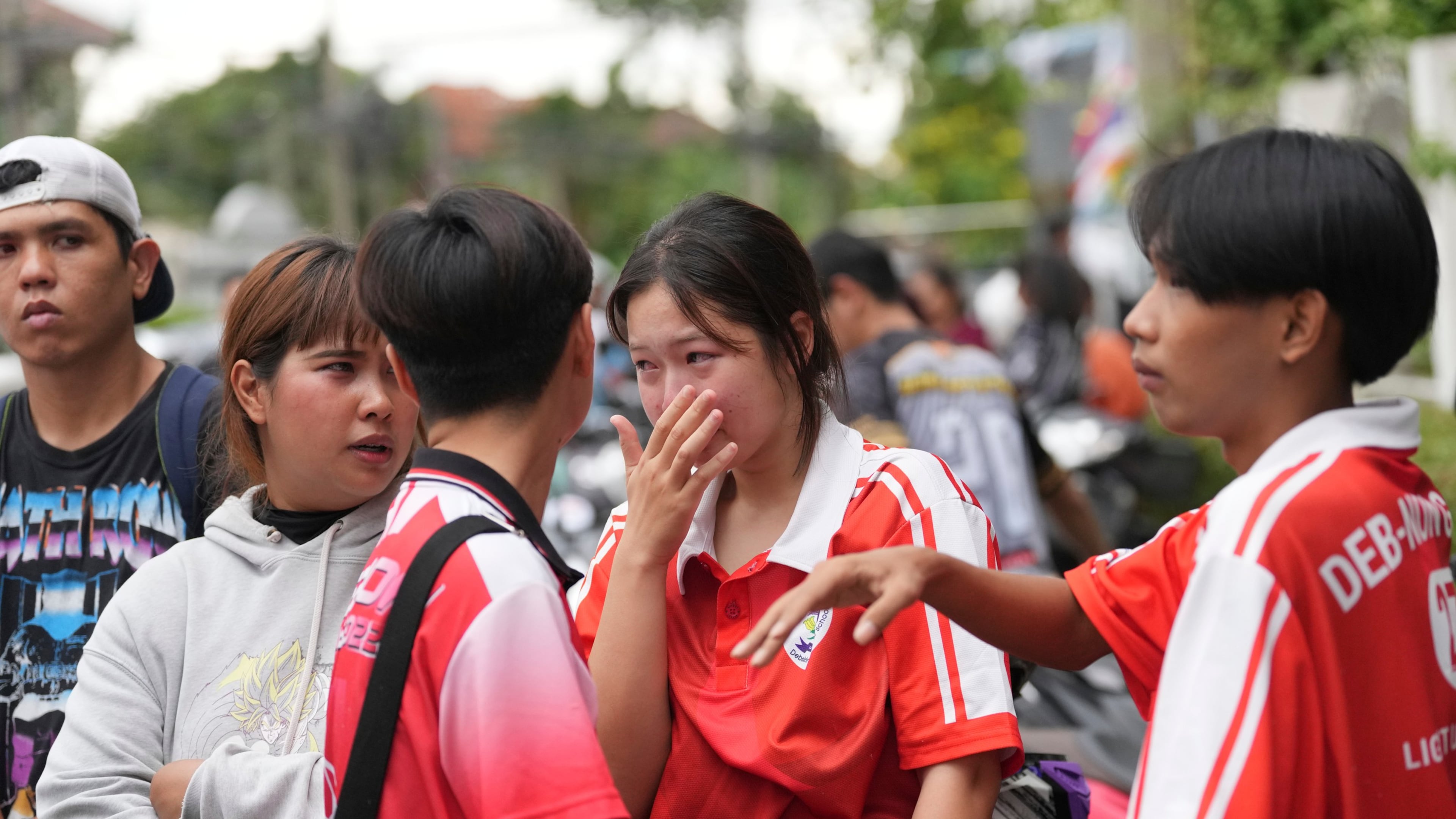 A schoolgirl cries outside her school where deaths and injuries were reported after a shooting in Thailand's Nonthaburi province, Friday, Aug. 7, 2026. (AP Photo/Sakchai Lalit)