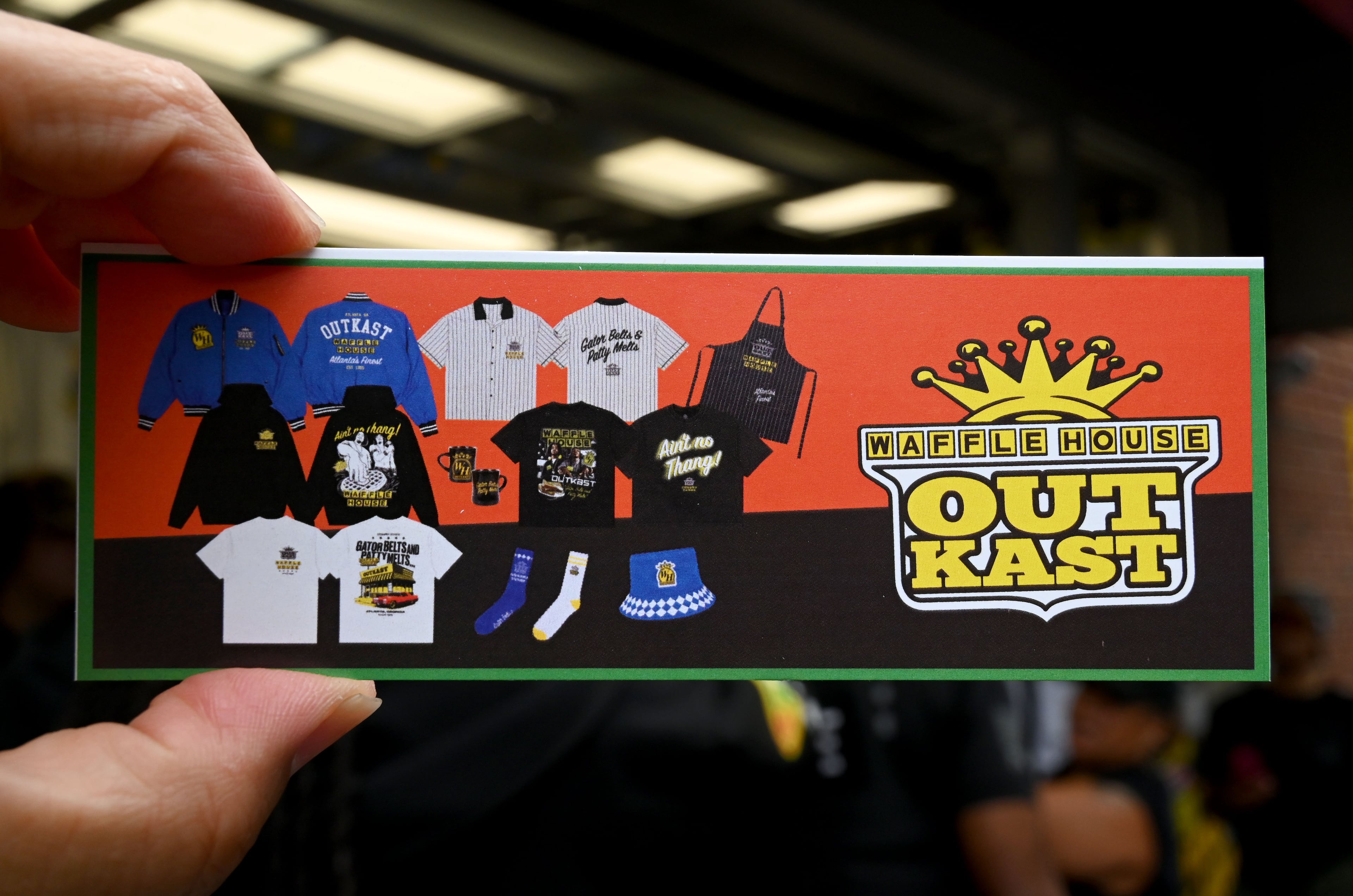 A complimentary coupon is shown during an exclusive launch event at the Centennial Olympic Park Waffle House on Friday, Oct. 2, 2026, in Atlanta. Outkast and Waffle House launched a limited-edition apparel and accessories collection celebrating Atlanta’s music and diner culture, highlighted by a pop-up event at the Centennial Olympic Park Waffle House. (Hyosub Shin/AJC)