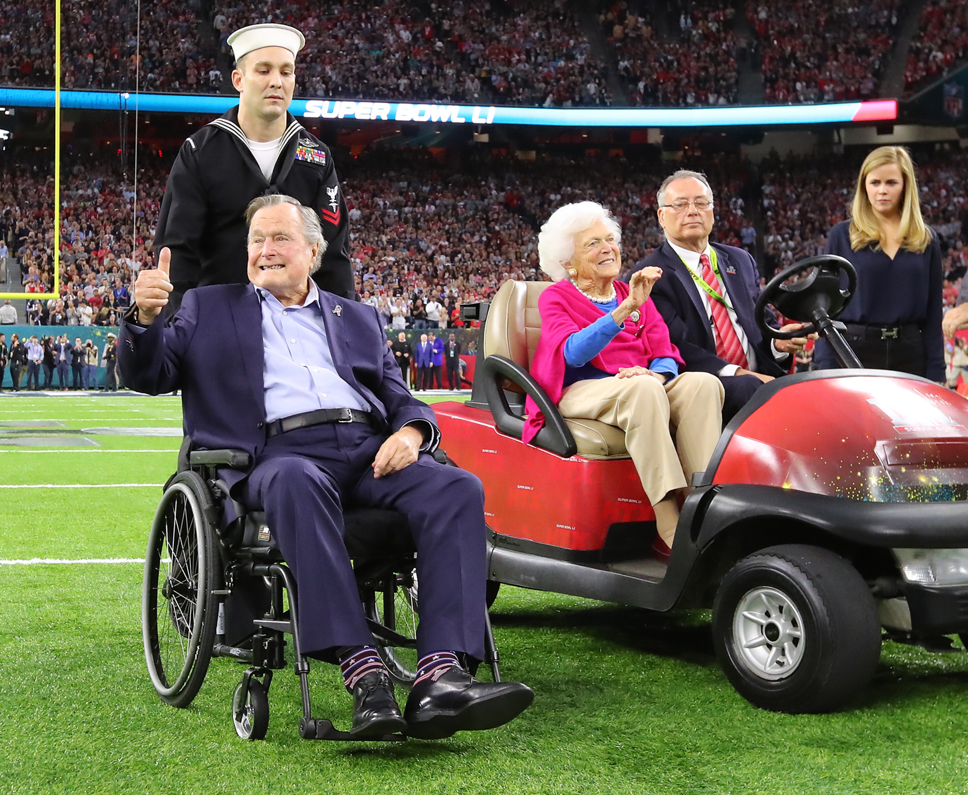 FEBRUARY 5, 2017 HOUSTON TX Former President George H.W. Bush gives the cheering crowd a thumbs up and former First Lady Barbara Bush waves as they take the field for the coin toss while the Atlanta Falcons meet the New England Patriots in Super Bowl LI at NRG Stadium in Houston, TX, Sunday, February 5, 2017. Curtis Compton/AJC