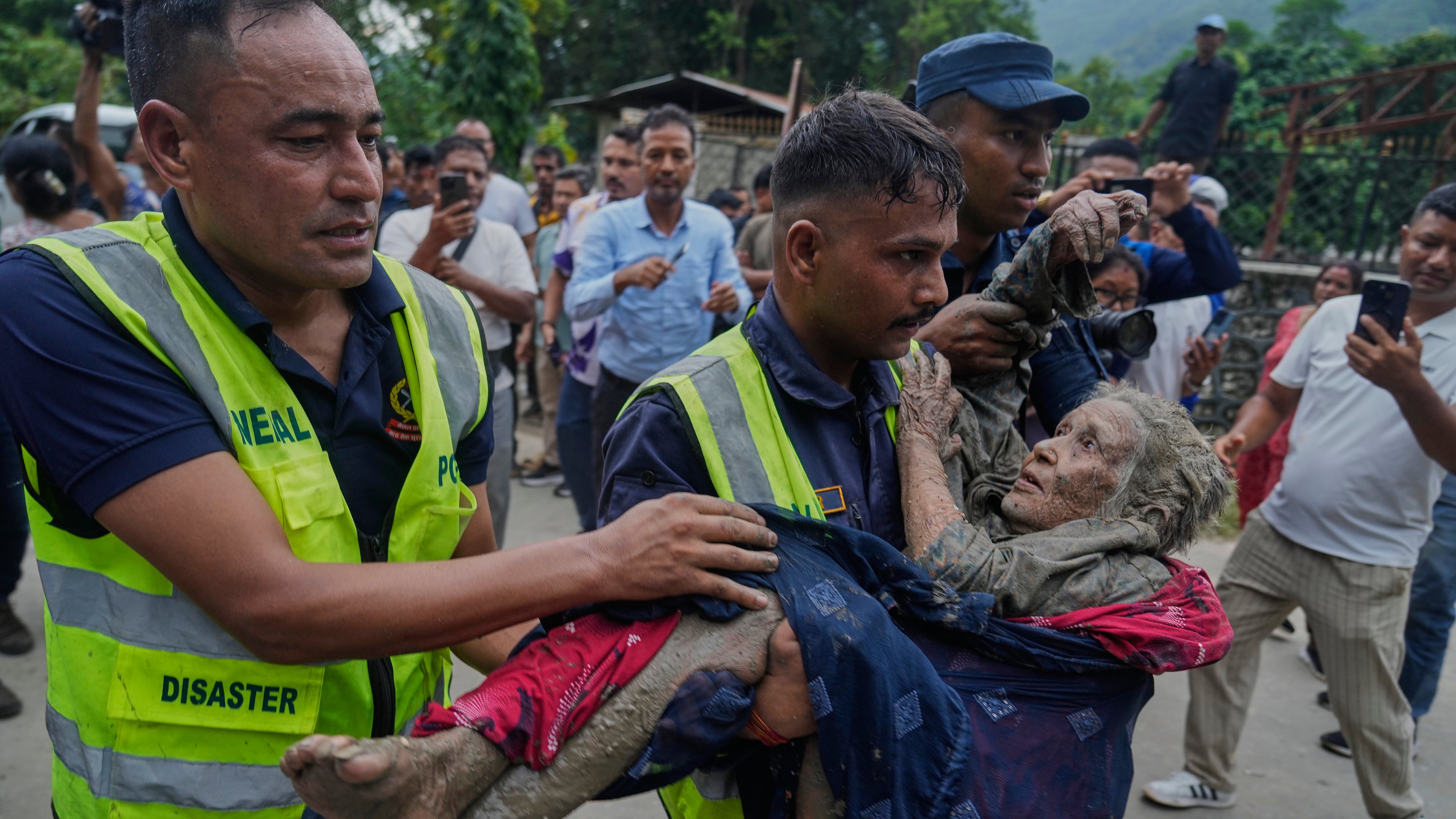 Rescuers carry a victim of flash flooding to safety along the Trishuli River in Nepal's Nuwakot district, Wednesday, Aug. 26, 2026. (AP Photo/Niranjan Shrestha)