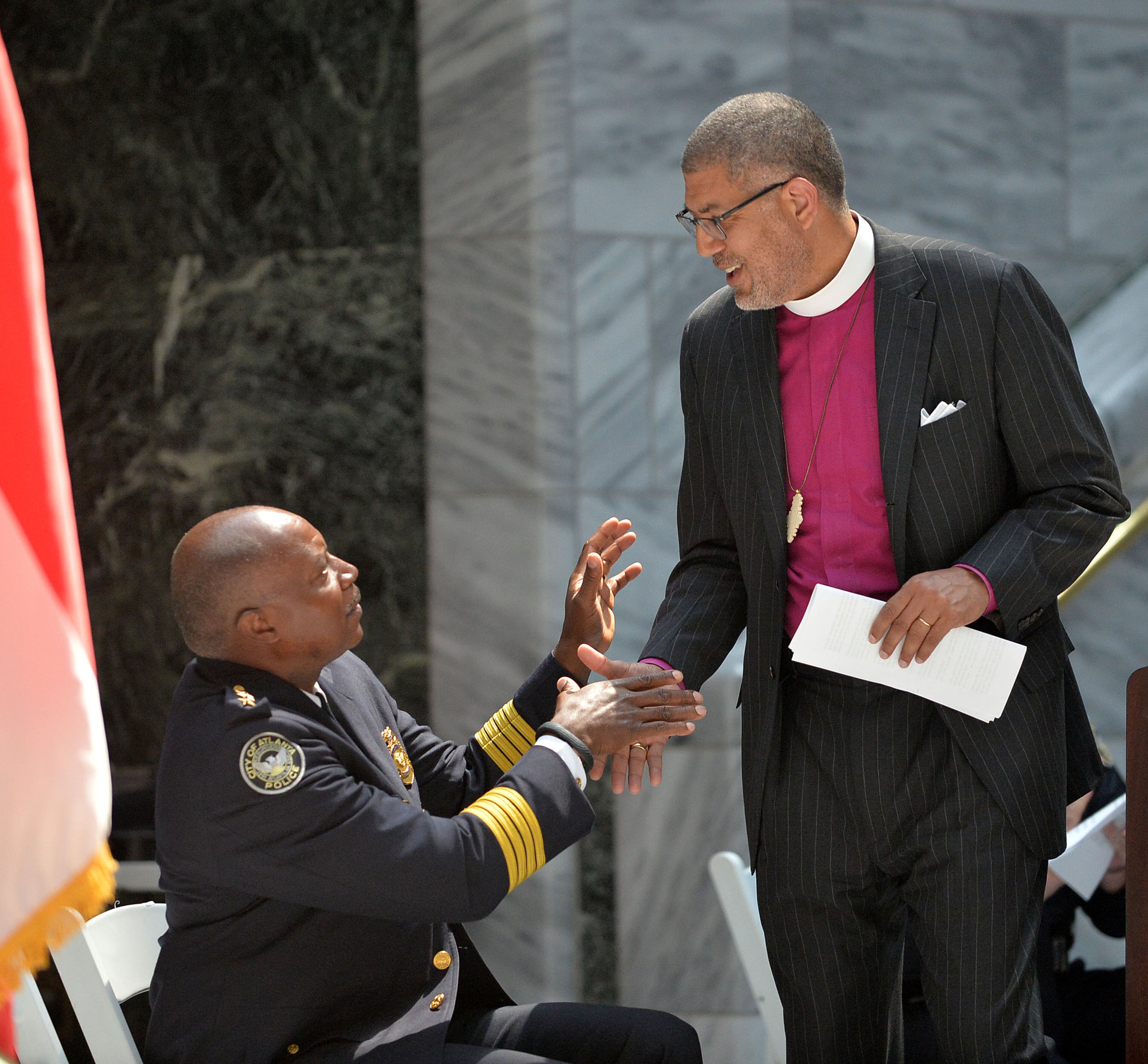 Atlanta Police Chief George Turner greets the Right Rev. Robert C. Wright of the Episcopal Diocese of Atlanta after he delivered the keynote address. The Atlanta Police Department recognized 82 fallen officers during the 24th Annual Police Memorial Service at the Atlanta City Hall atrium, Tuesday, May 5, 2015. Additional speakers included Atlanta Police Chief George N. Turner, Michael Geisler, Chief Operating Officer, City Council President Ceasar C. Mitchell and Council member C.T. Martin, Public Safety Chair. KENT D. JOHNSON /KDJOHNSON@AJC.COM