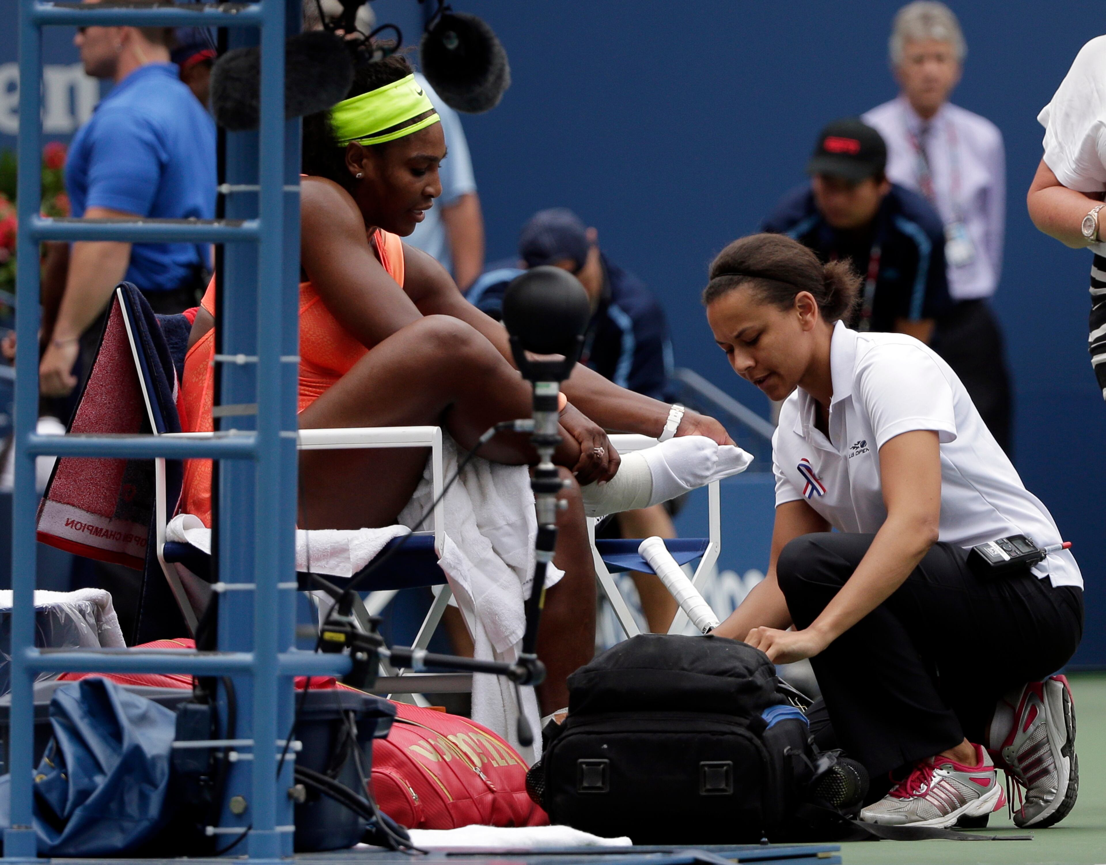 Serena Williams is treated by a trainer during a break in play during a semifinal match against Roberta Vinci, of Italy, at the U.S. Open tennis tournament, Friday, Sept. 11, 2015, in New York. (AP Photo/Bill Kostroun)