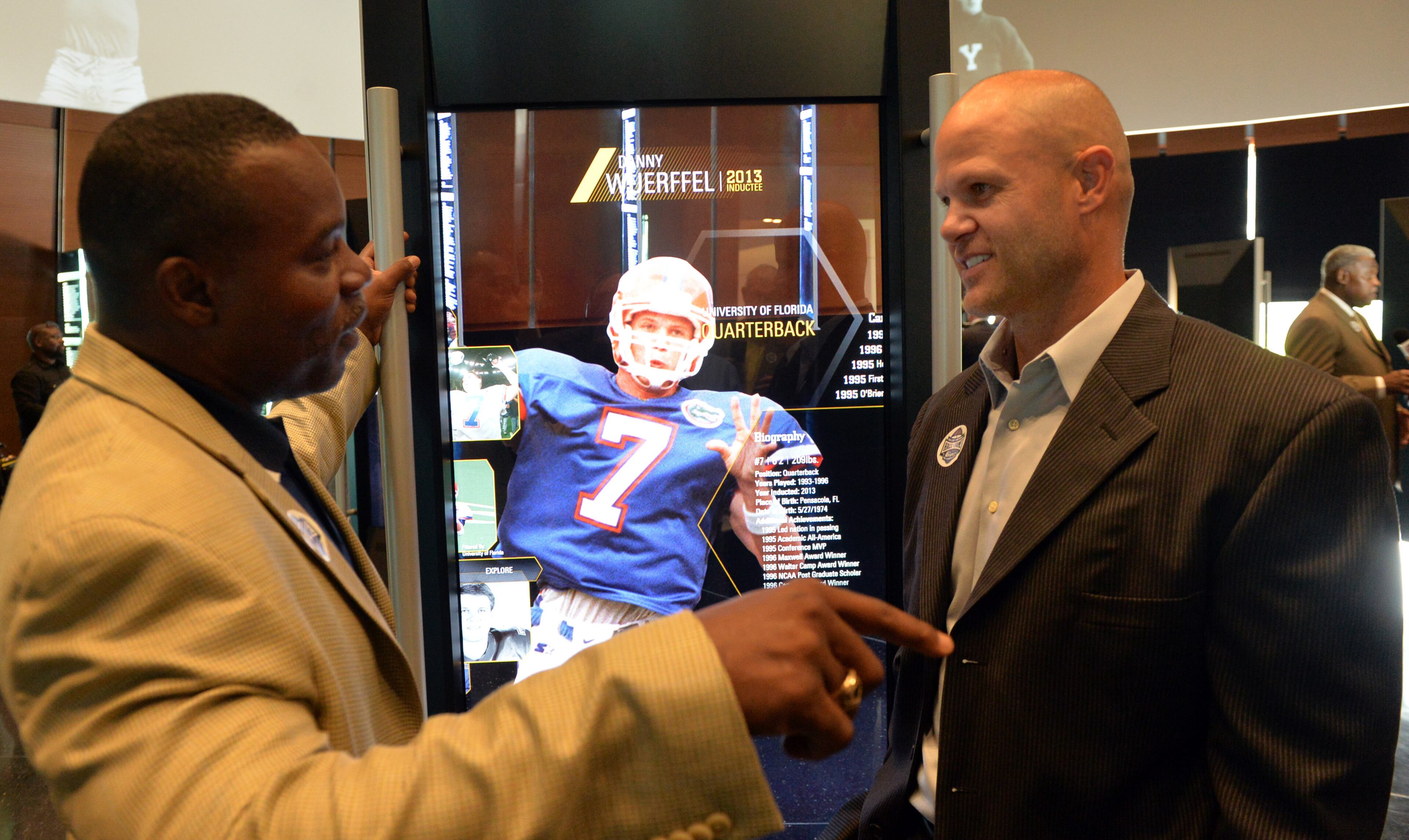 Hall of Fame quarterbacks Tracy Ham (Georgia Southern) and Danny Wuerffel (Florida) talk as they look over exhibits in the Hall of Fame area, a few days before the museum opens to the public.