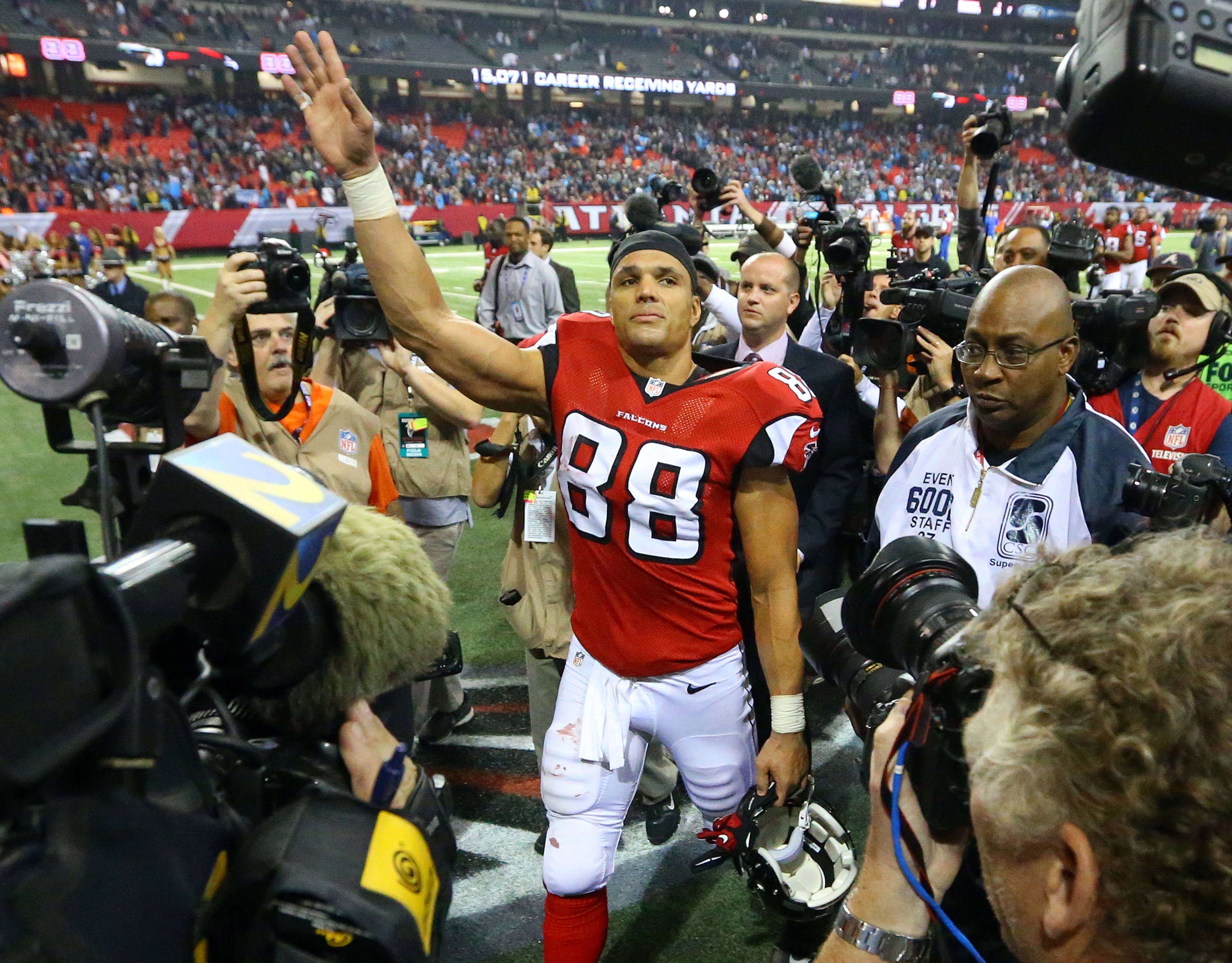 Falcons tight end Tony Gonzalez is surrounded by media as he waves farewell to fans walking off the field after playing his final NFL football game against the Panthers on Sunday, Dec. 29, 2013, in Atlanta.