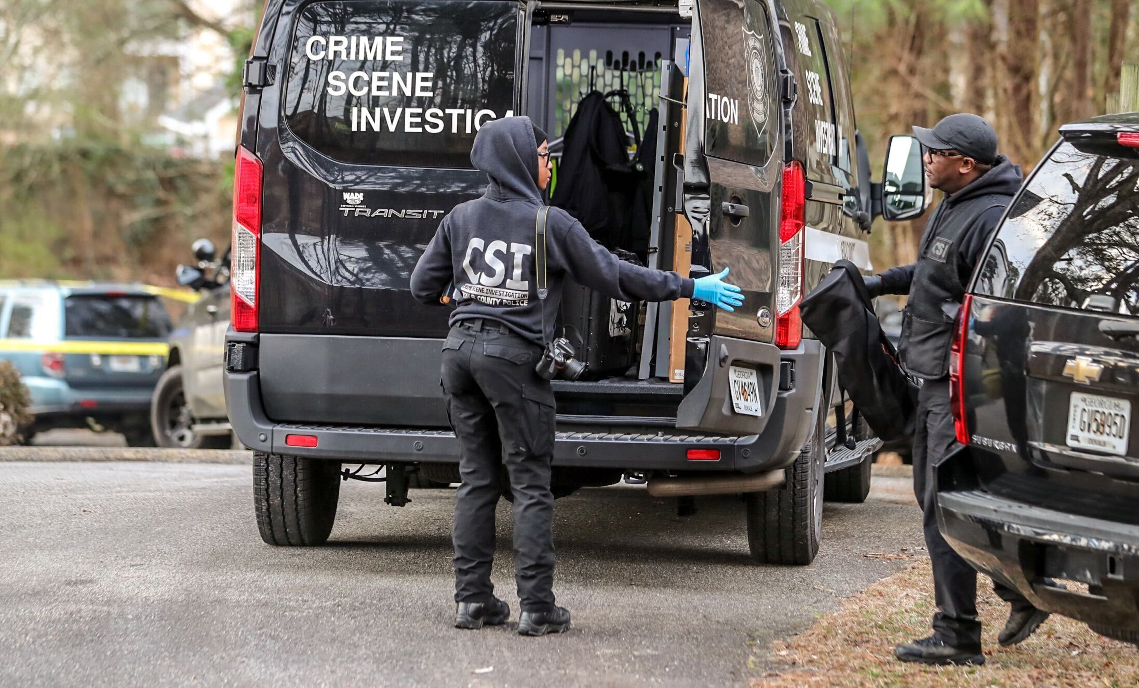 Crime scene investigators examine the scene of a shooting Tuesday morning at a DeKalb County apartment complex.
