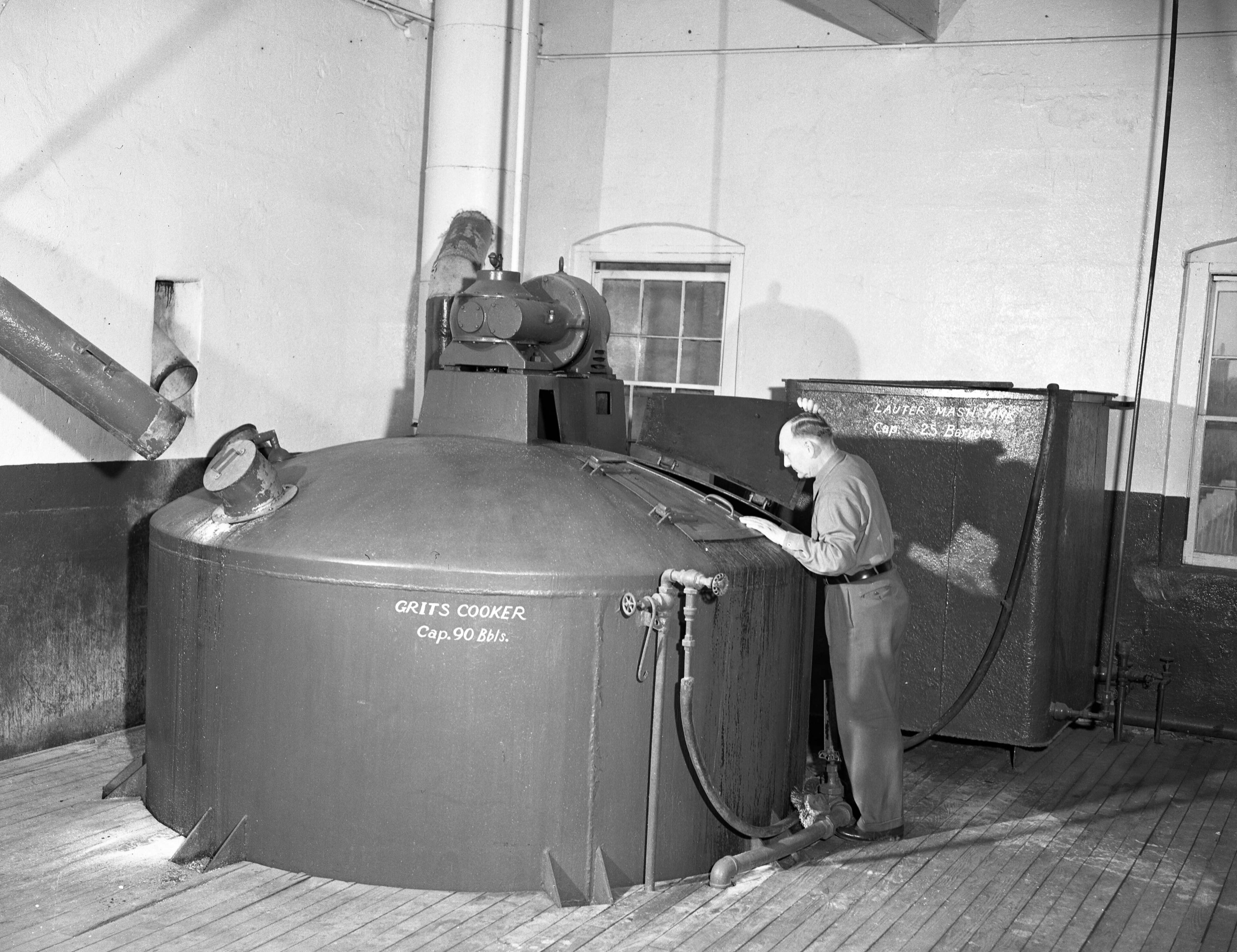 A worker checks the 'Grits Cooker.' This is the beginning of the cooking process for producing 'Schweitzer-ized' Atlantic beer. This is done just before the malt goes into the mash tubs for further crushing.