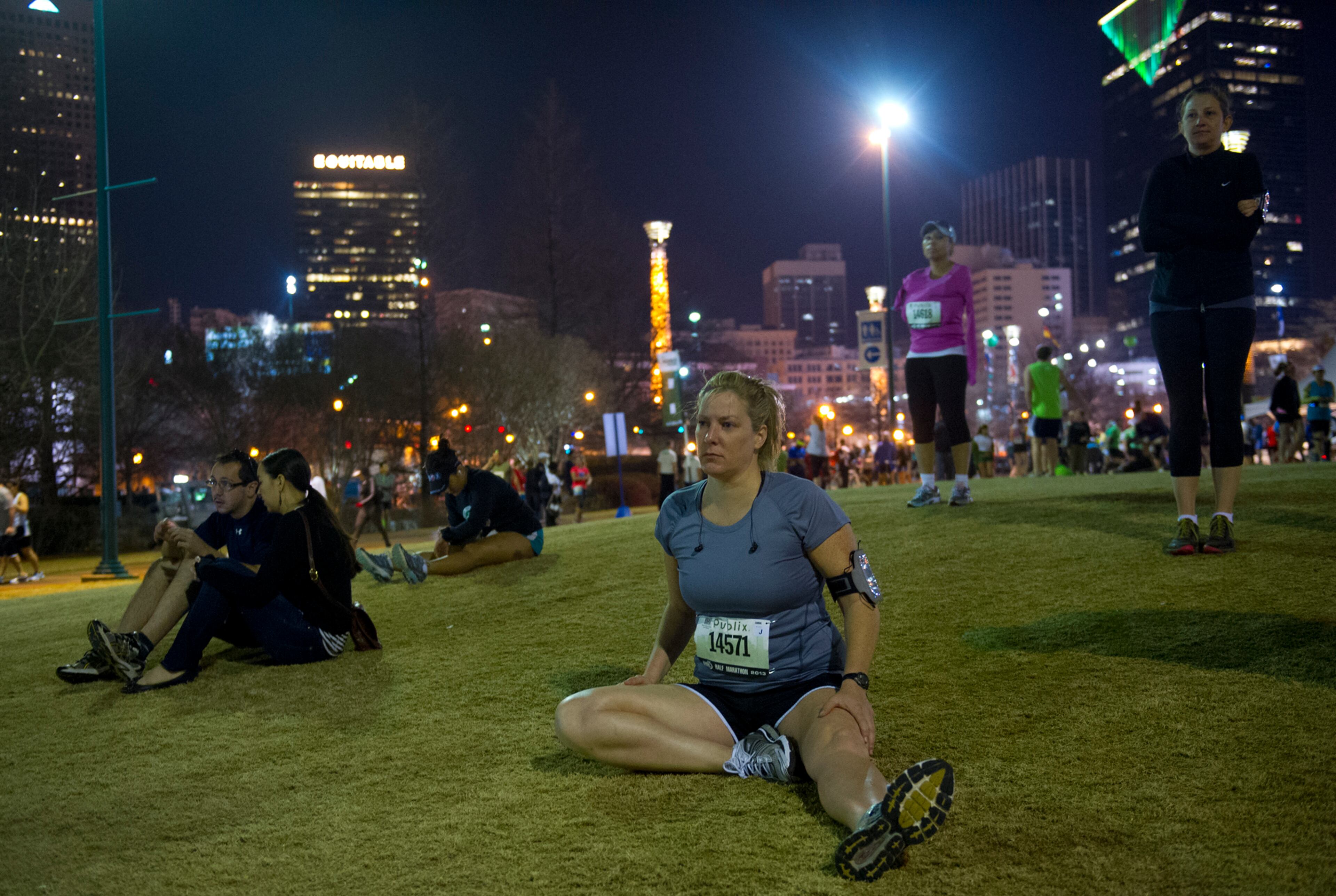 130317 Atlanta: Mary Larson (14571) stretches in Centennial Olympic Park as runners gather for the 2013 Publix Georgia Marathon/Half Marathon in Atlanta on Sunday, March 17, 2013. Over 16,000 runners participated in the marathon, half marathon and 5k races on the St. Patrick's Day morning. Jonathan Phillips Special