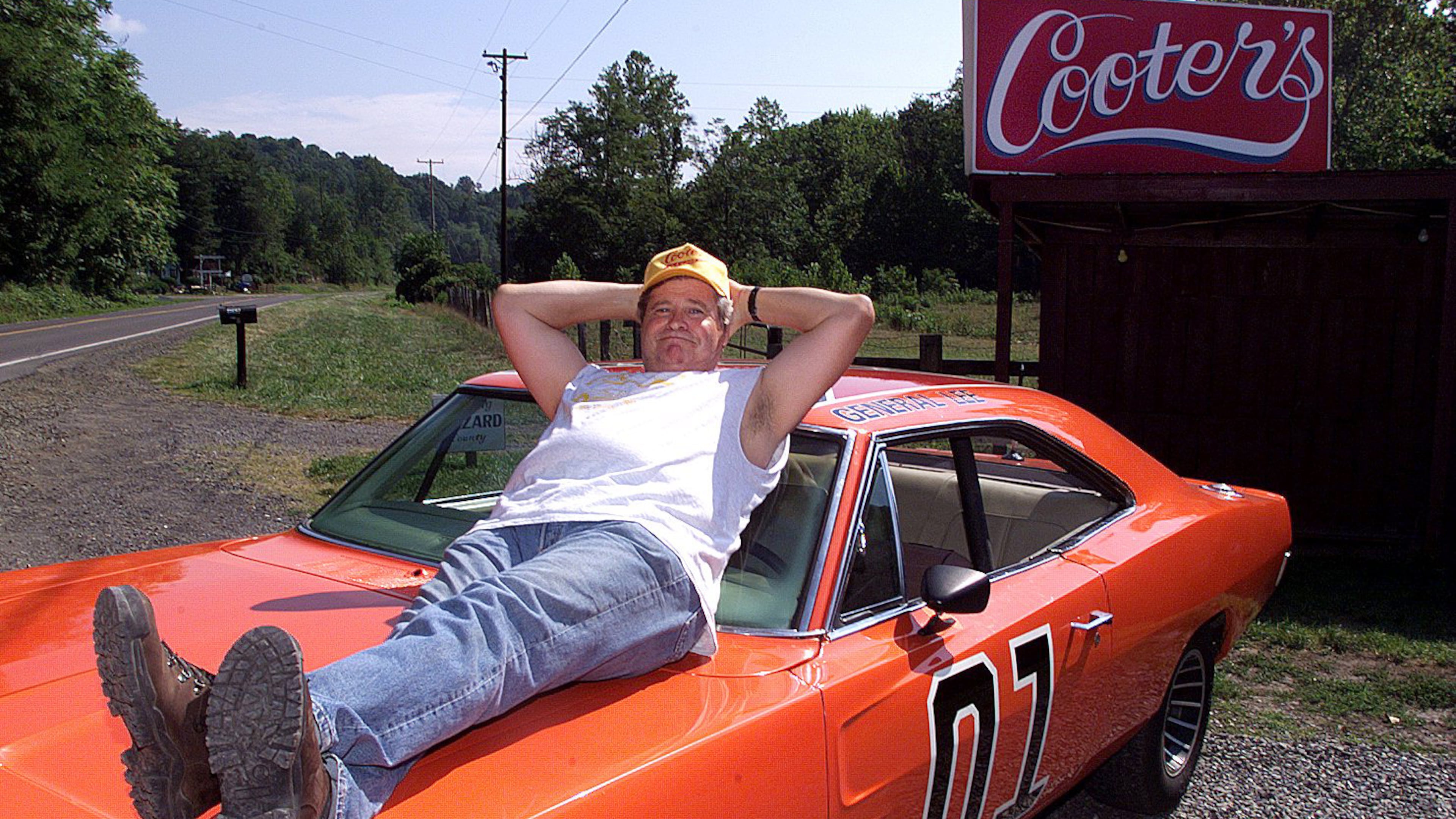 Ben Jones sits atop the General Lee, an orange 1969 Dodge Charger, outside "Cooter's," his roadside store in Sperryville, Va. Jones, who served from 1989 to 1993 as a Democratic congressman from Georgia, returned to his "Dukes of Hazzard" roots after his time in office, living his role as Cooter, the show's greasy, good-natured mechanic. From Thursdays through Sundays, Jones presided at a garage converted to the "Hazzard General Store" beside a two-lane highway winding toward Shenandoah National Park. (Rick McKay/Cox Washington Bureau 1999)