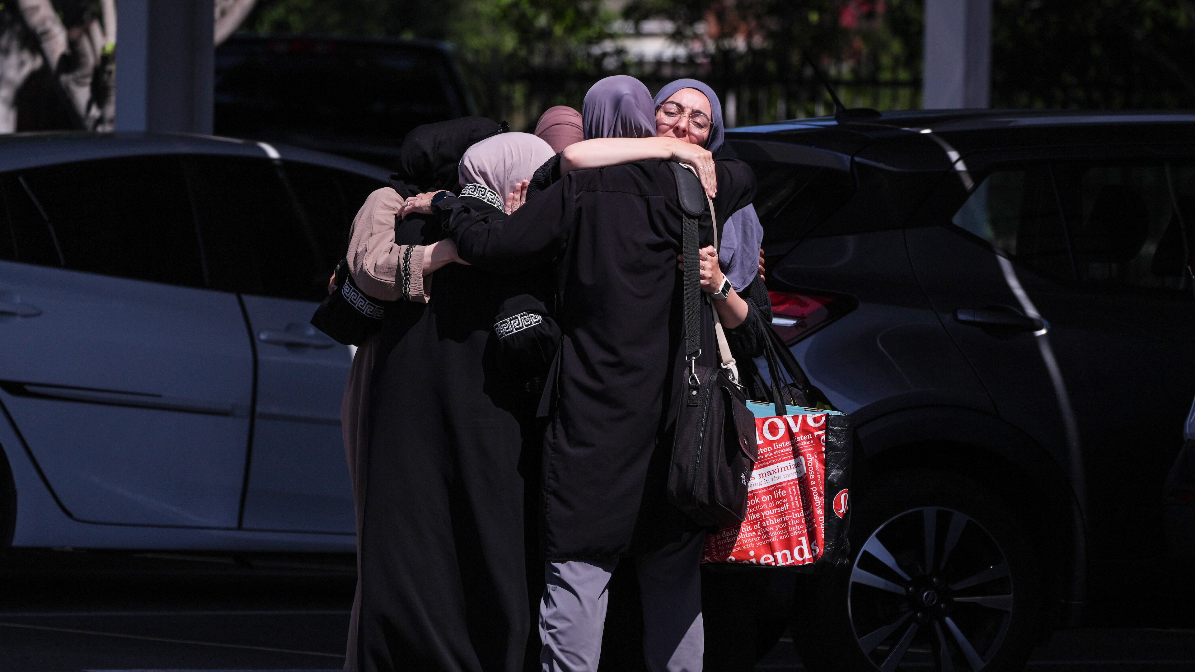 People embrace outside of the Islamic Center of San Diego, a day after a shooting, Tuesday, May 19, 2026, in San Diego. (AP Photo/Jae C. Hong)