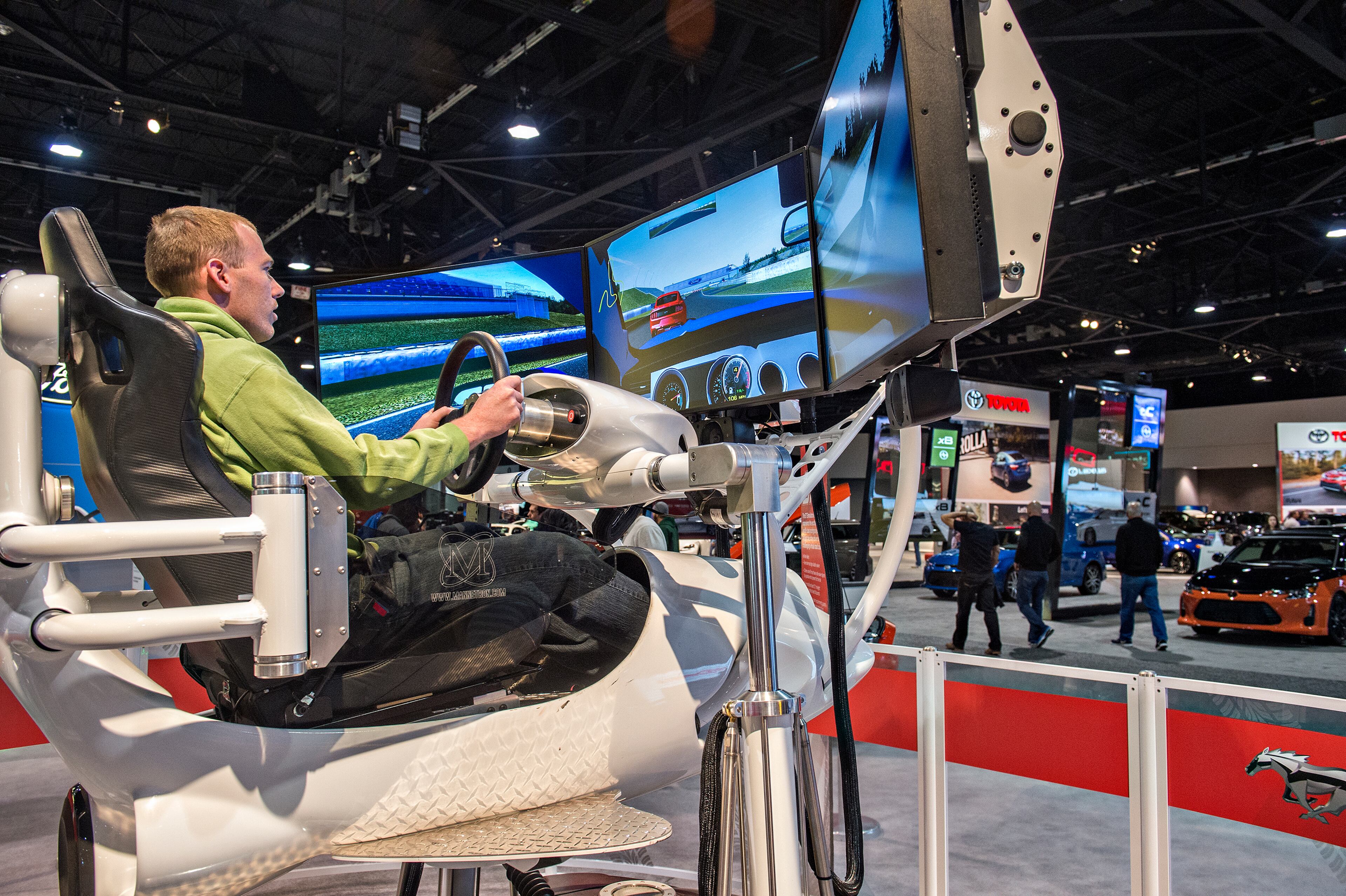 March 29, 2015 Atlanta - Chas Keithan (left) tests his skills in a driving simulator during the Atlanta International Auto Show at the Georgia World Congress Center on Sunday, March 29, 2015. The four day show featured automobiles from 29 different manufacturers including Jeep, Chevrolet, Alfa Romeo, Lexus, BMW, Nissan, Volkswagen and more. JONATHAN PHILLIPS / SPECIAL