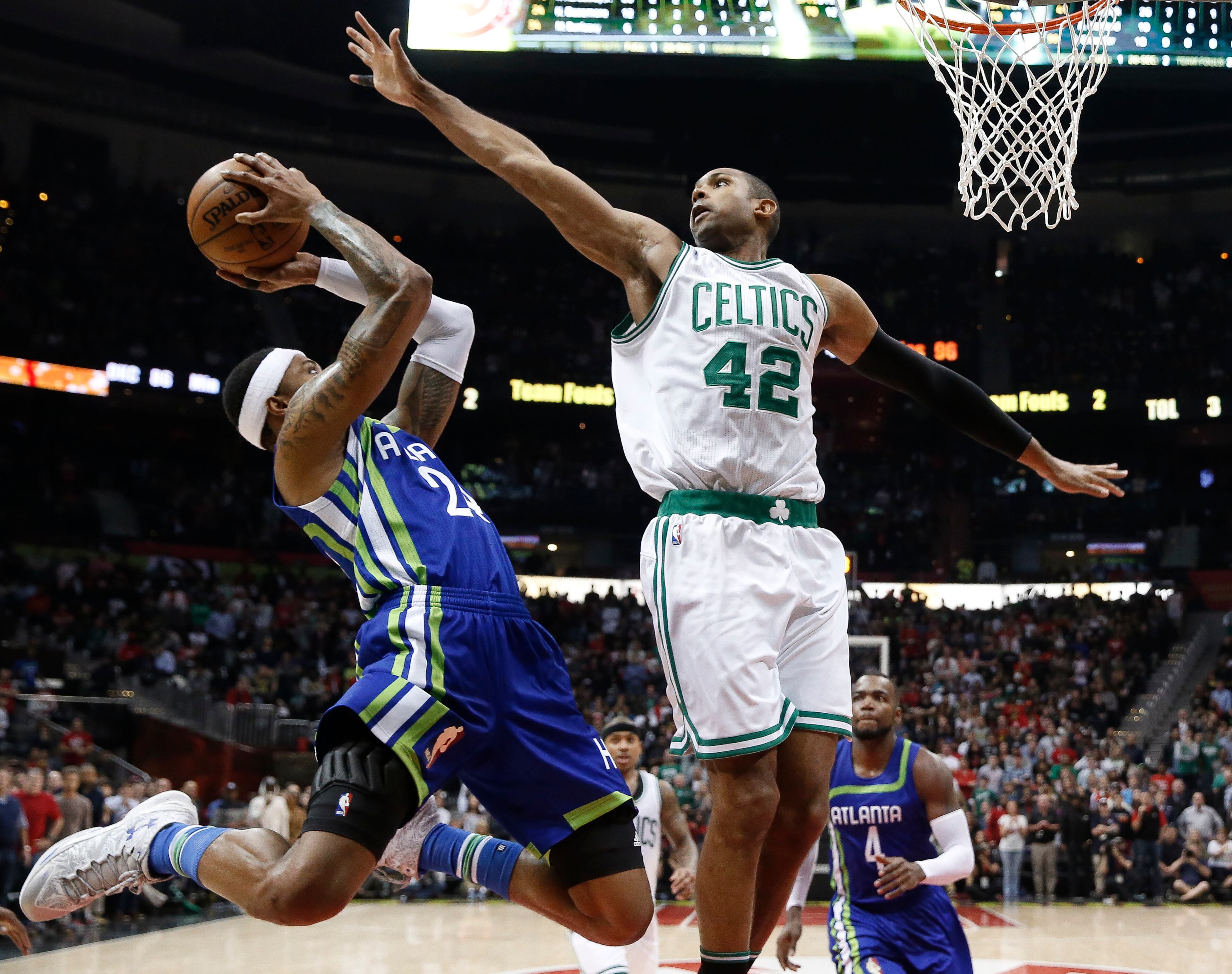 Atlanta Hawks forward Kent Bazemore (24) goes in for a shot as Boston Celtics center Al Horford (42) defends during the second half of an NBA basketball game Friday, Jan. 13, 2017, in Atlanta. Boston won 103-101. (AP Photo/John Bazemore)
