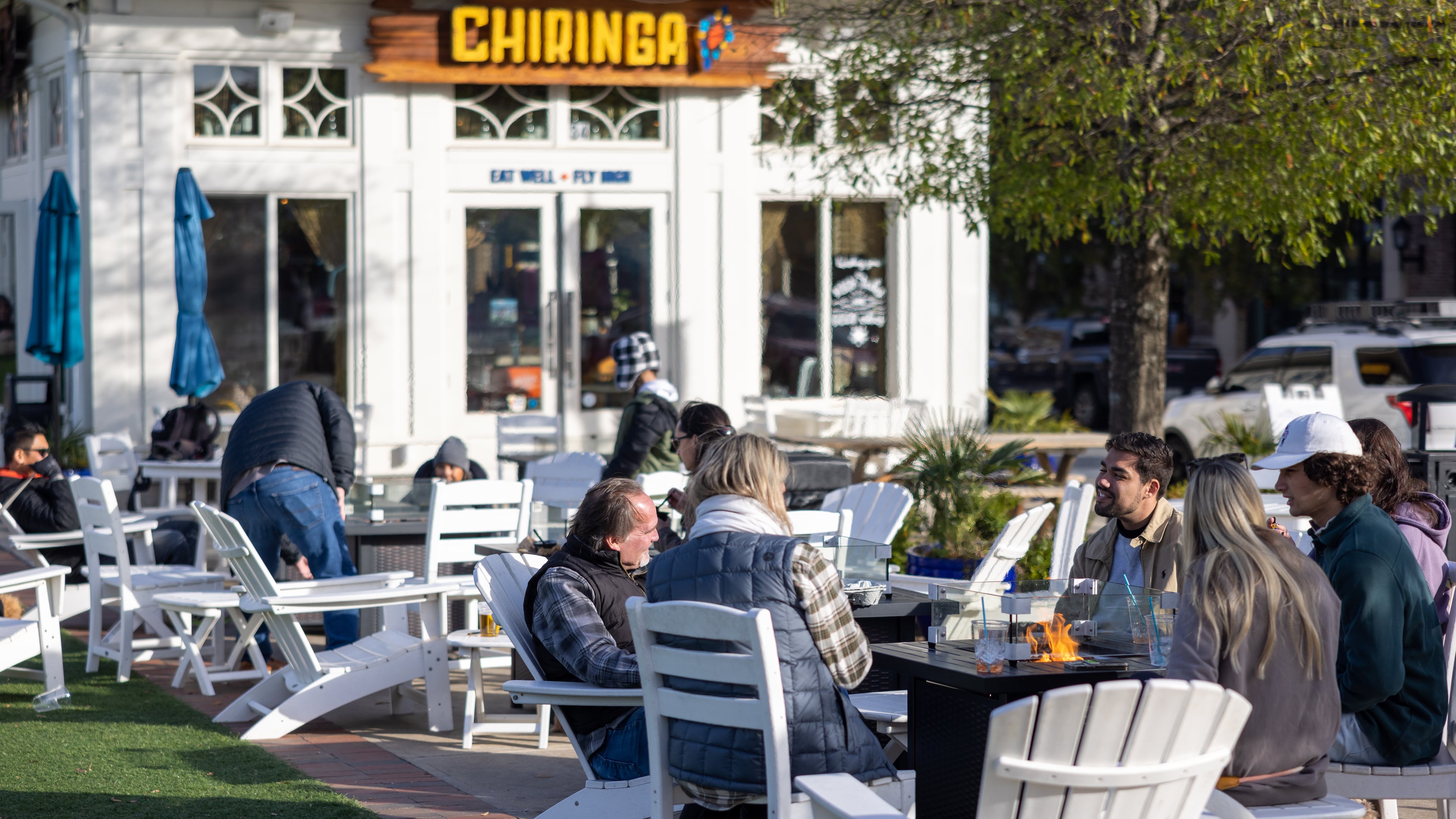 People talking by fire infront of Chiringa in downtown Alpharetta on November 20, 2022