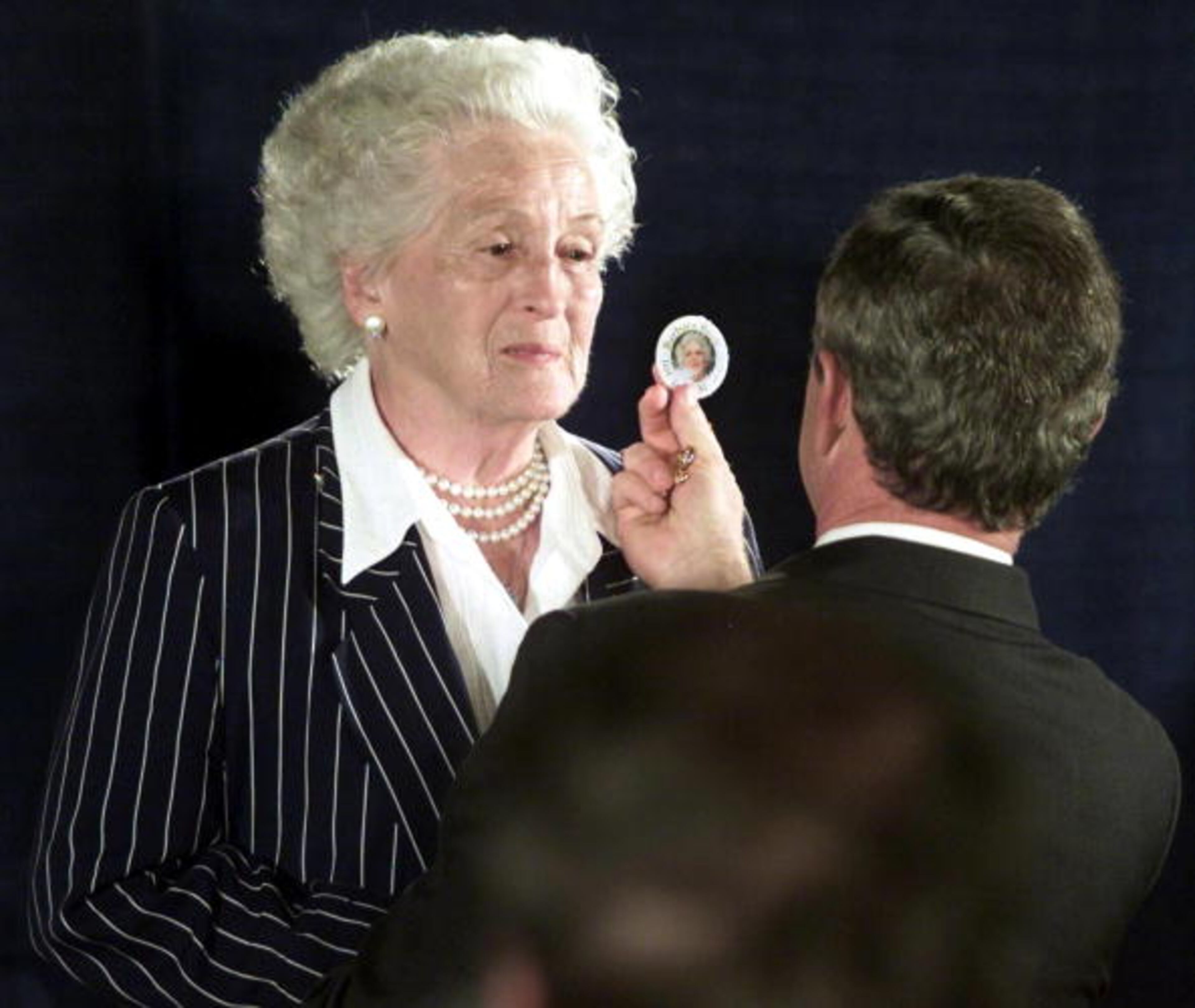 SCRANTON, UNITED STATES: Texas Governor and Republican presidential candidate George W. Bush (R) compares a campaign button bearing the image of his mother, Barbara Bush, to Frances DeWitt (L) following his speech at Community Medical Center in 05 September 2000 in Scranton, Pennsylvania. DeWitt bears a striking resemblance to Bush's mother Barbara. (ELECTRONIC IMAGE) AFP PHOTO/Paul BUCK (Photo credit should read PAUL BUCK/AFP/Getty Images)