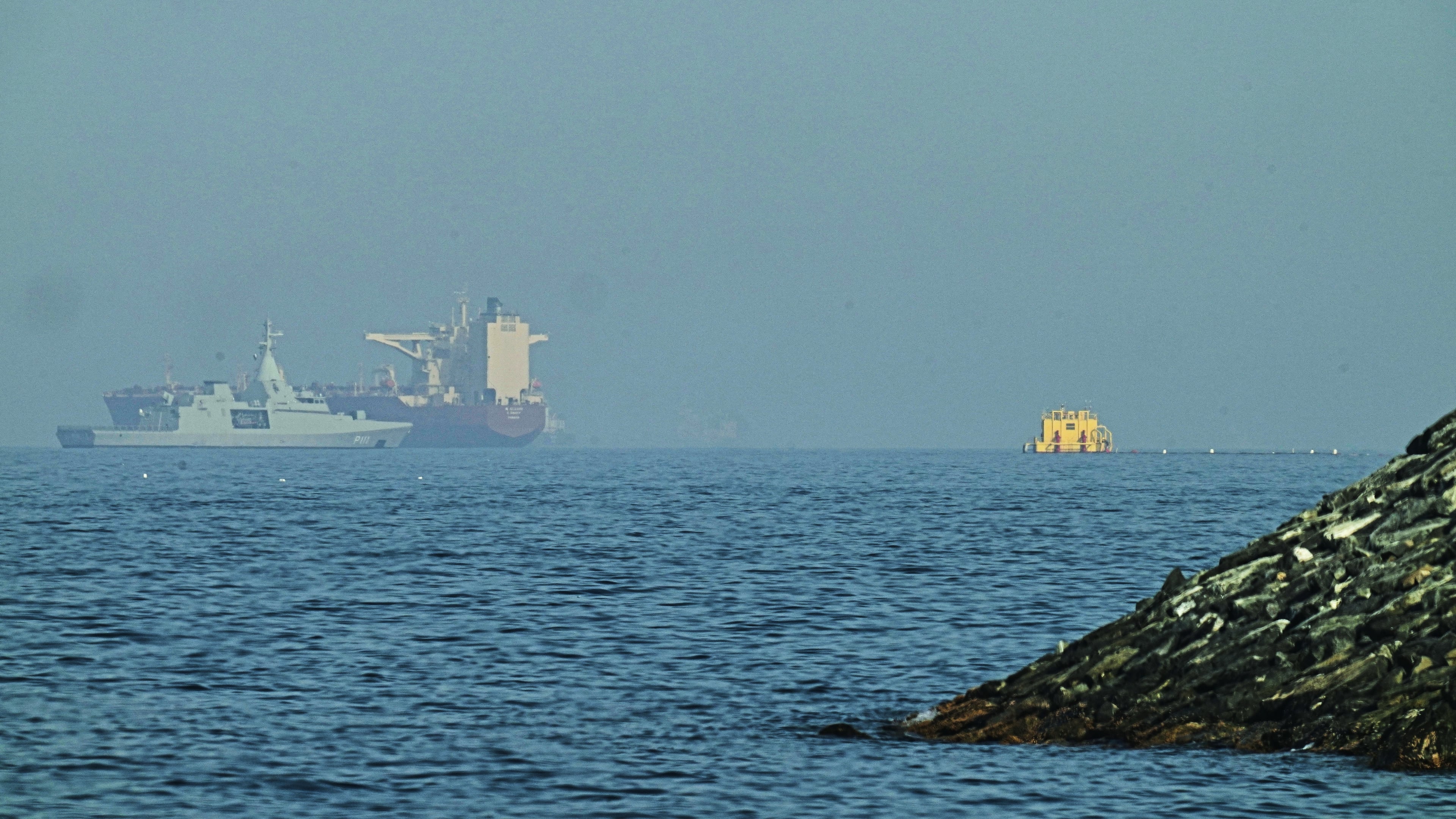 An Emirati patrol boat, left, is near a tanker anchored in the Gulf of Oman near the Strait of Hormuz, as seen from a coastal road near Khor Fakkan, United Arab Emirates, Friday, May 1, 2026. (AP Photo/Fatima Shbair)