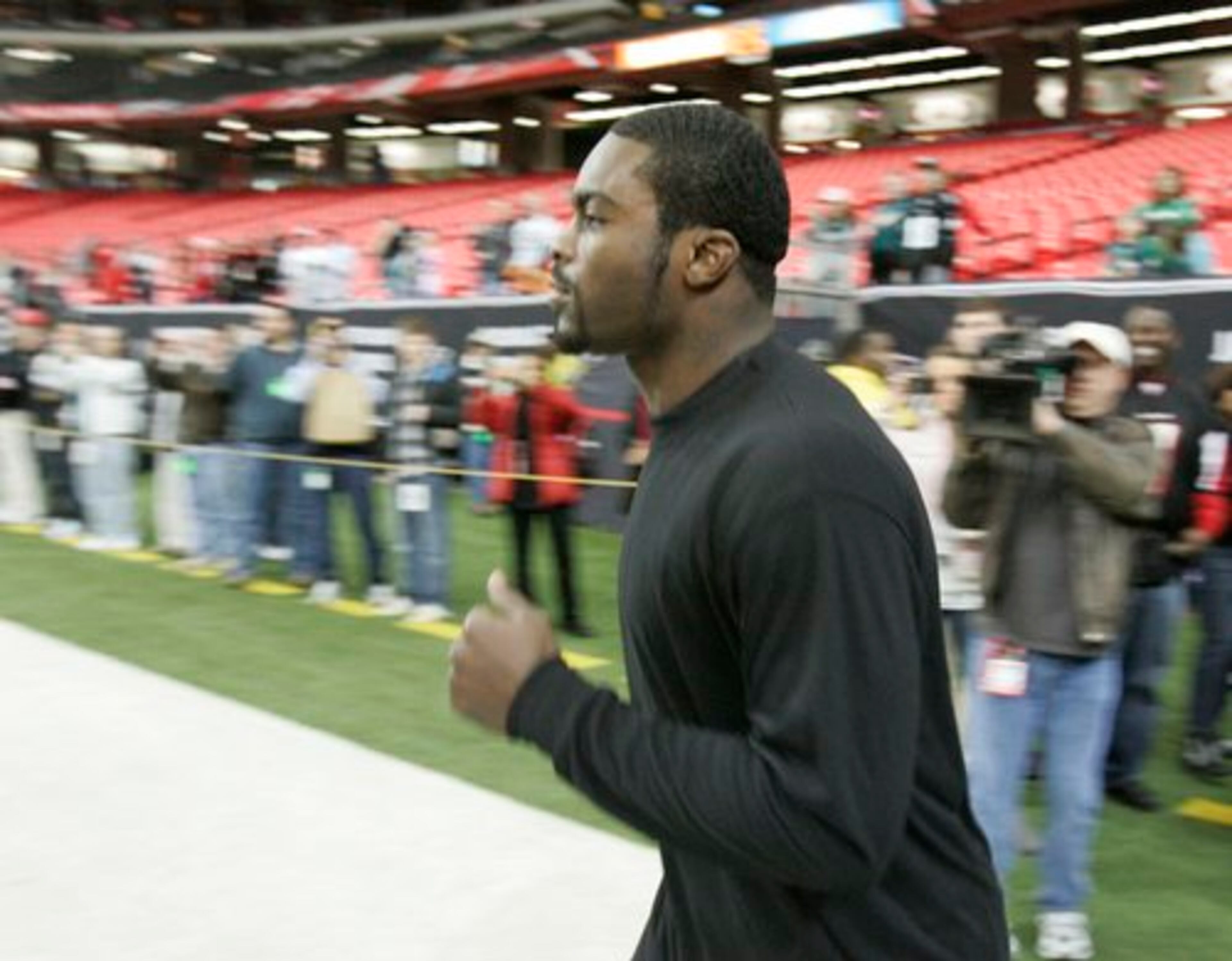 Former Falcons quarterback Michael Vick runs onto the field an hour-and-a-half before kickoff for warmups.