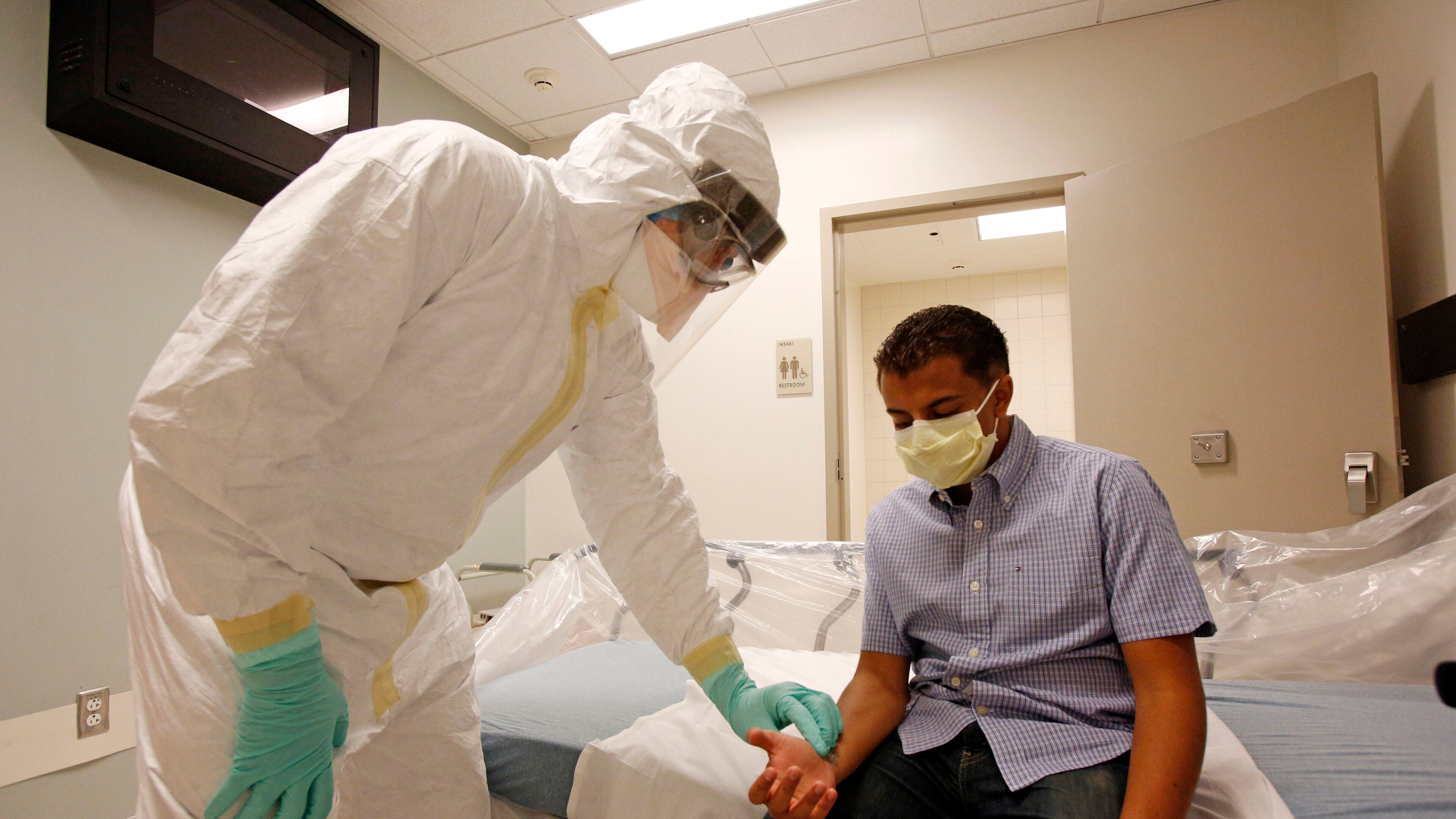In this photo provided by the UCLA Health System, doctors and staff participate in a preparadness exercise on diagnosing and treating patients with Ebola virus symptoms, at the Ronald Reagan UCLA Medical Center in Los Angeles. The exercise was observed by Los Angeles County health department officials. UCLA’s multi-pronged approach includes protocols for transporting patients through the hospital, disposing of trash and waste, dedicating equipment -- such as ventilators and X-ray machines -- for Ebola patient use only, setting up a mobile laboratory, acquiring specialized personal protective equipment and staff training. (AP Photo/UCLA Health System, Reed Hutchinson)
