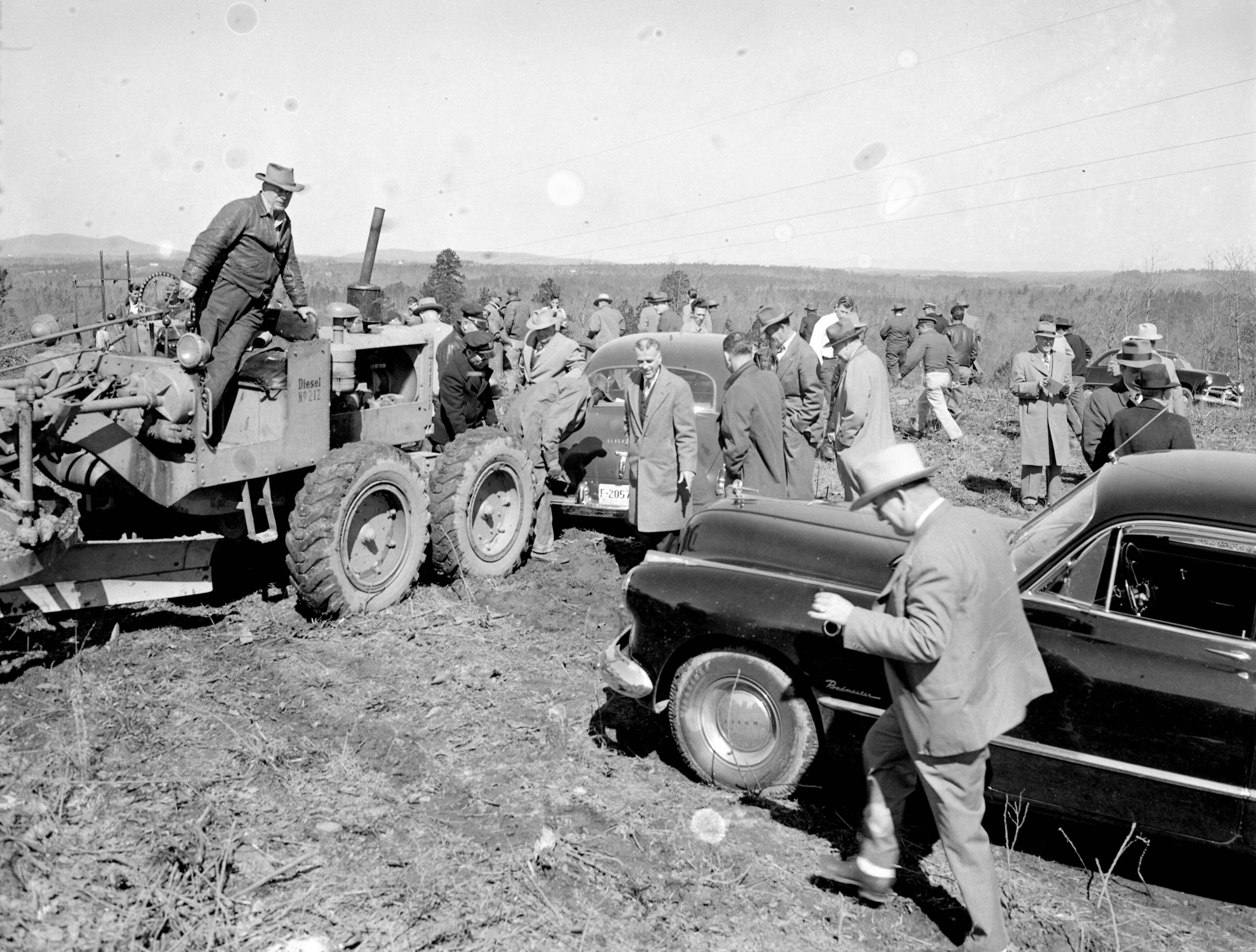 Fulton County Chief of Police Neal Ellis' car being towed out of the mud at the Buford Dam ground breaking ceremony, Buford, Georgia, March 3, 1950. Photo: Jimmie Fitzpatrick / AJC