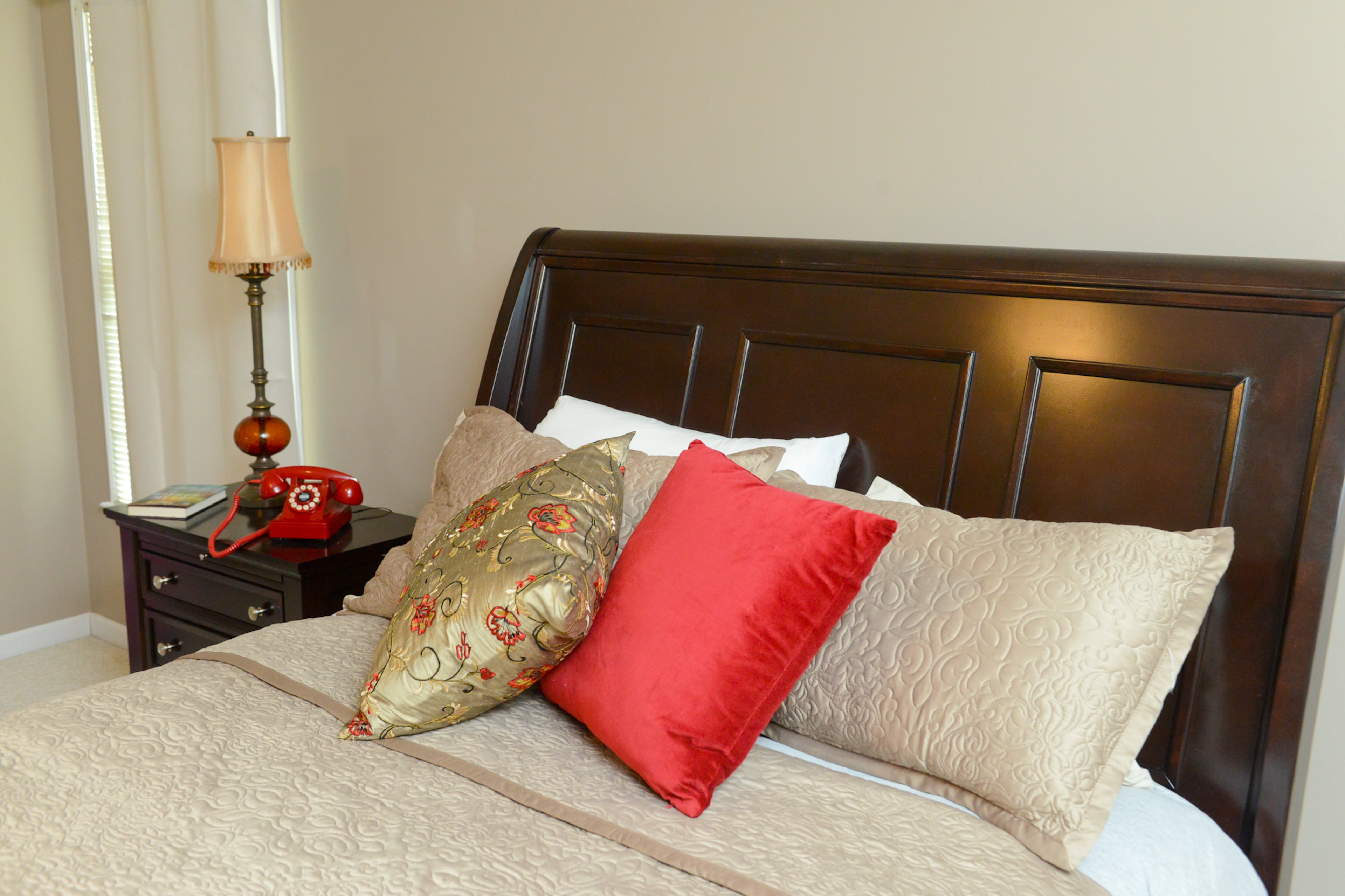 Homeowner Shannon Joy brings pops of red into her decor, such as the phone, pillows and lamp in the master bedroom.