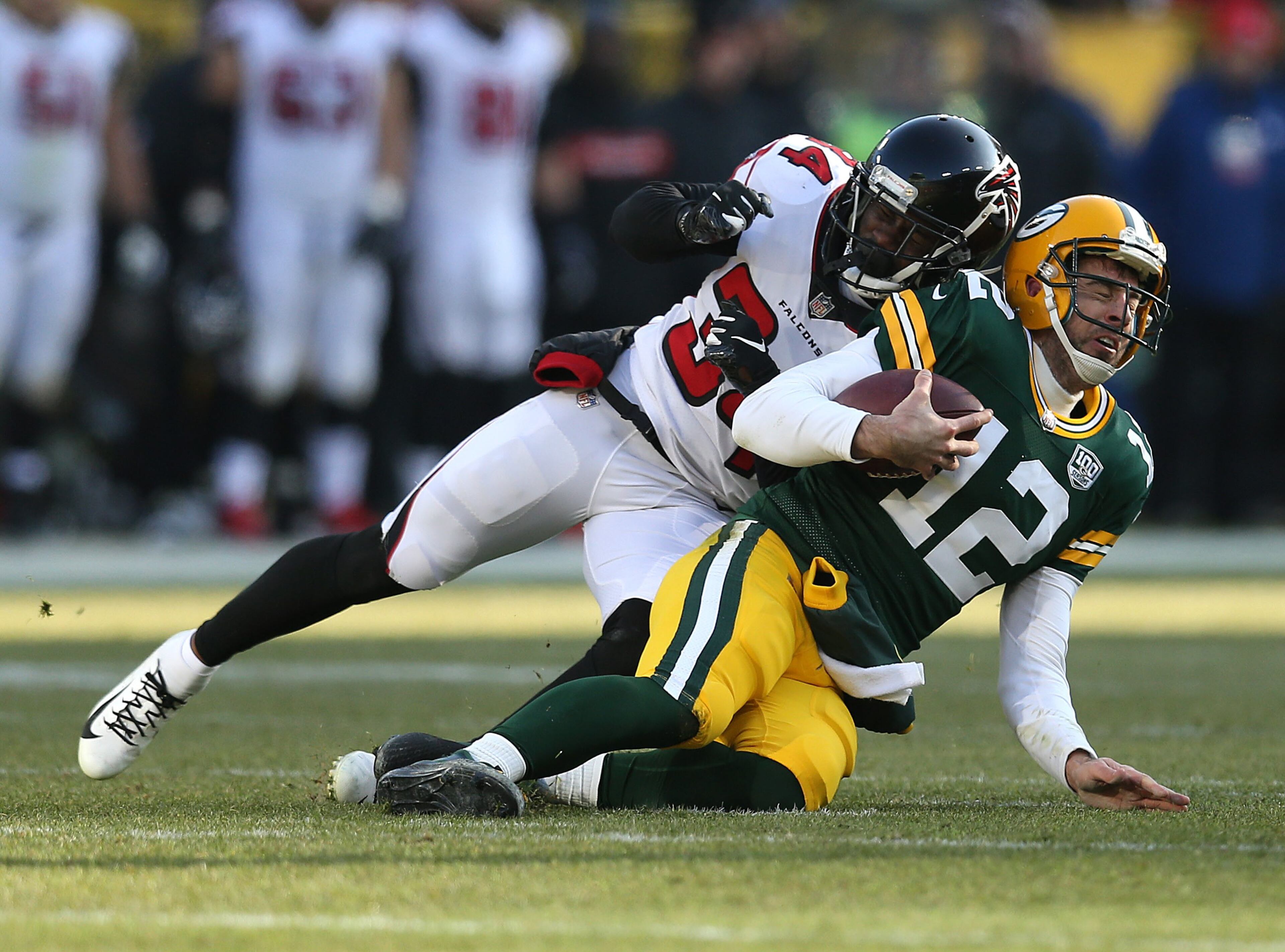GREEN BAY, WISCONSIN - DECEMBER 09: Aaron Rodgers #12 of the Green Bay Packers is tackled by Brian Poole #34 of the Atlanta Falcons during the first half of a game at Lambeau Field on December 09, 2018 in Green Bay, Wisconsin. (Photo by Dylan Buell/Getty Images)