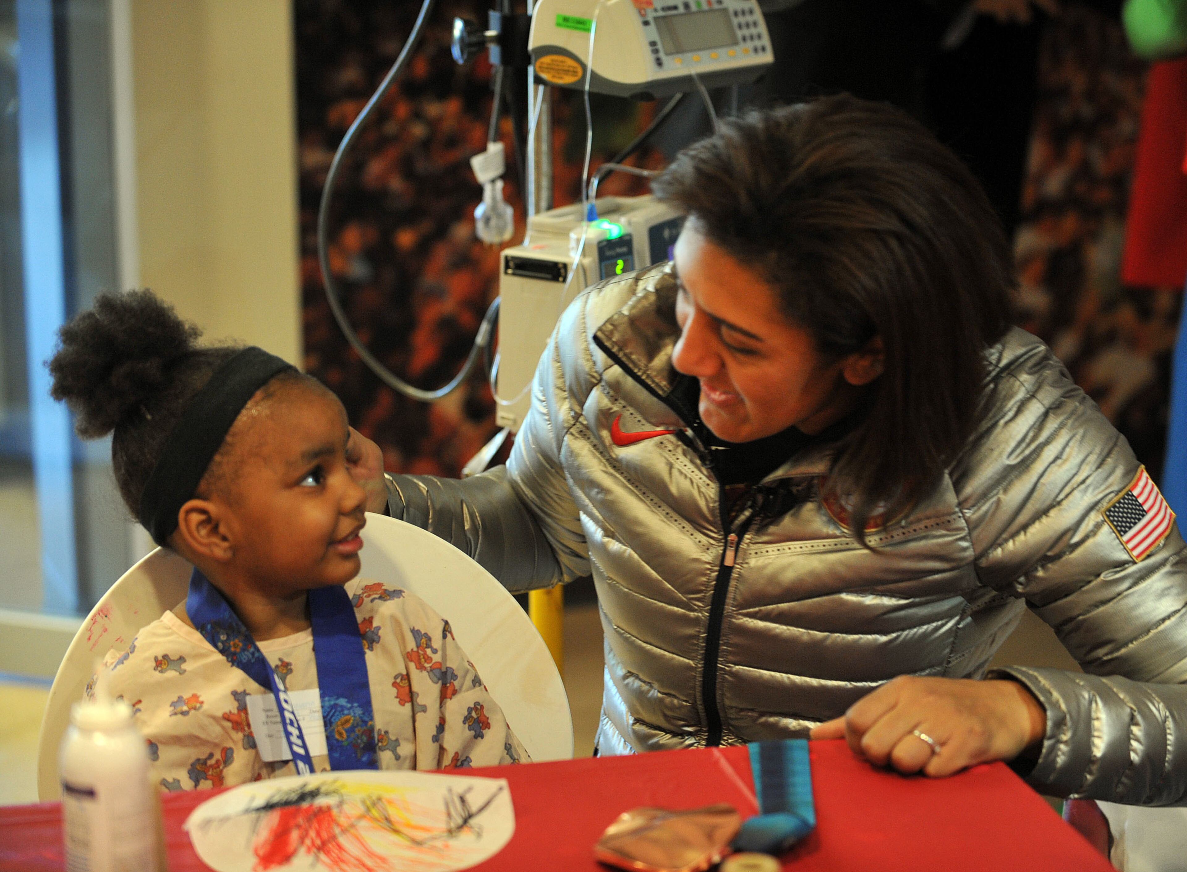 Elana Meyers talks with Deshawna Dennis, 4, of East Point. The Douglasville-native finished second in the bobsled competition in Sochi, Russia on Feb. 19, becoming the first U.S. women's bobsledder to win multiple Olympic medals. KENT D. JOHNSON / KDJOHNSON@AJC.COM