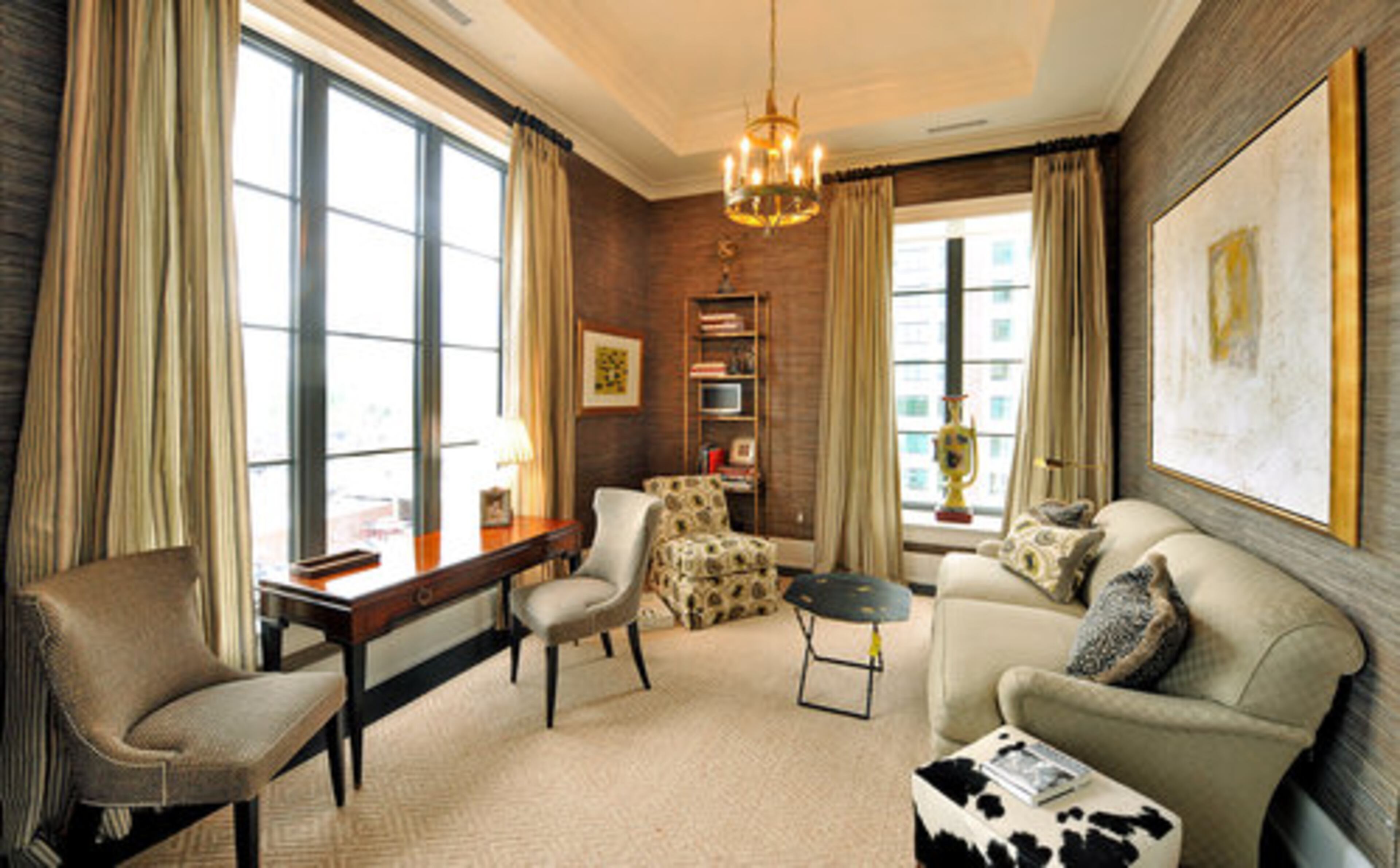 Designer Carole Weaks created this cozy study off the transitional unit's living room with grasscloth wallcovering, subdued color palette and gold accents.