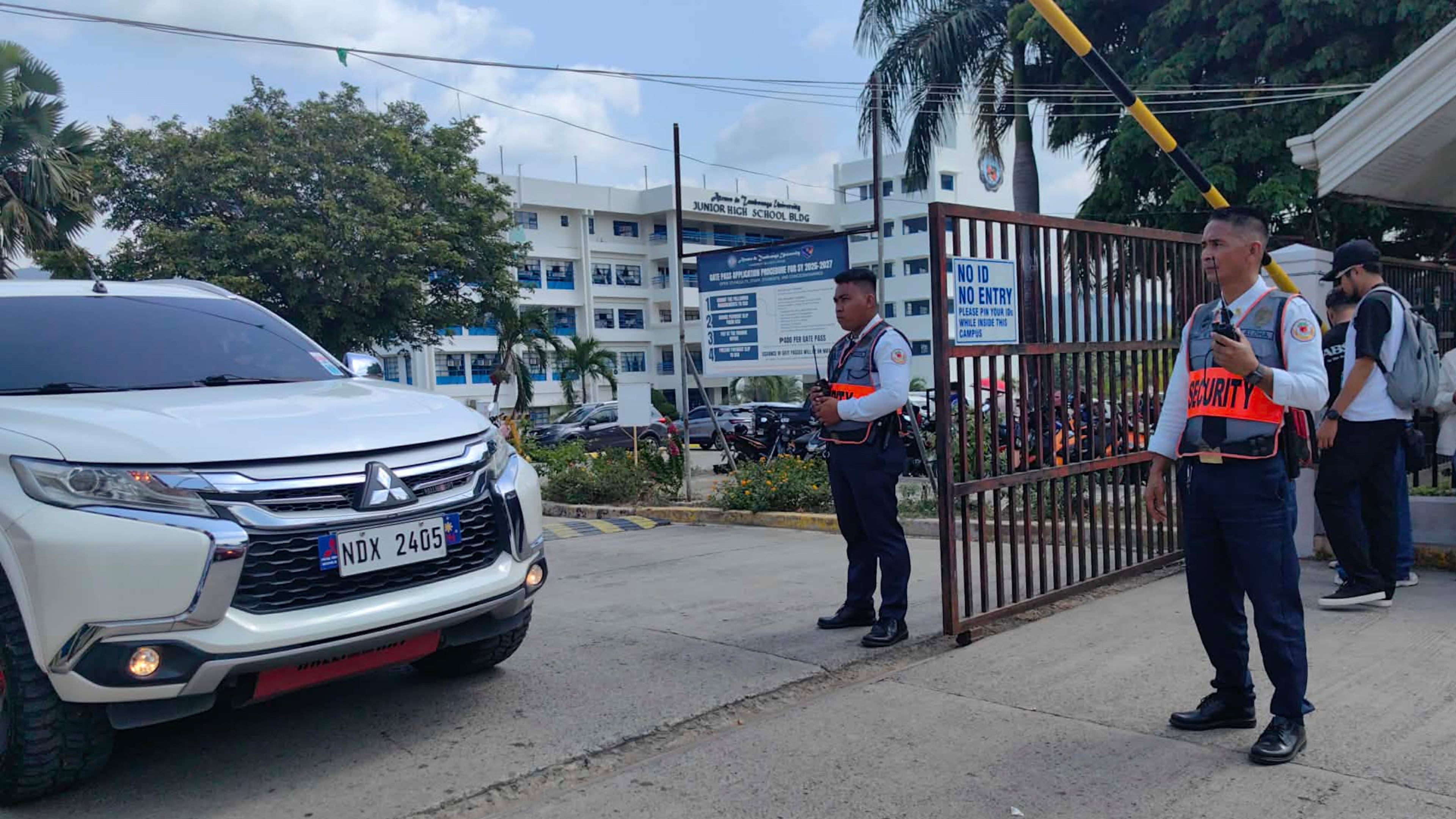 Security guards keep watch as vehicles exit the Ateneo de Zamboanga University following a shooting incident in Zamboanga, southern Philippines Tuesday, Aug. 18, 2026. (AP Photo)