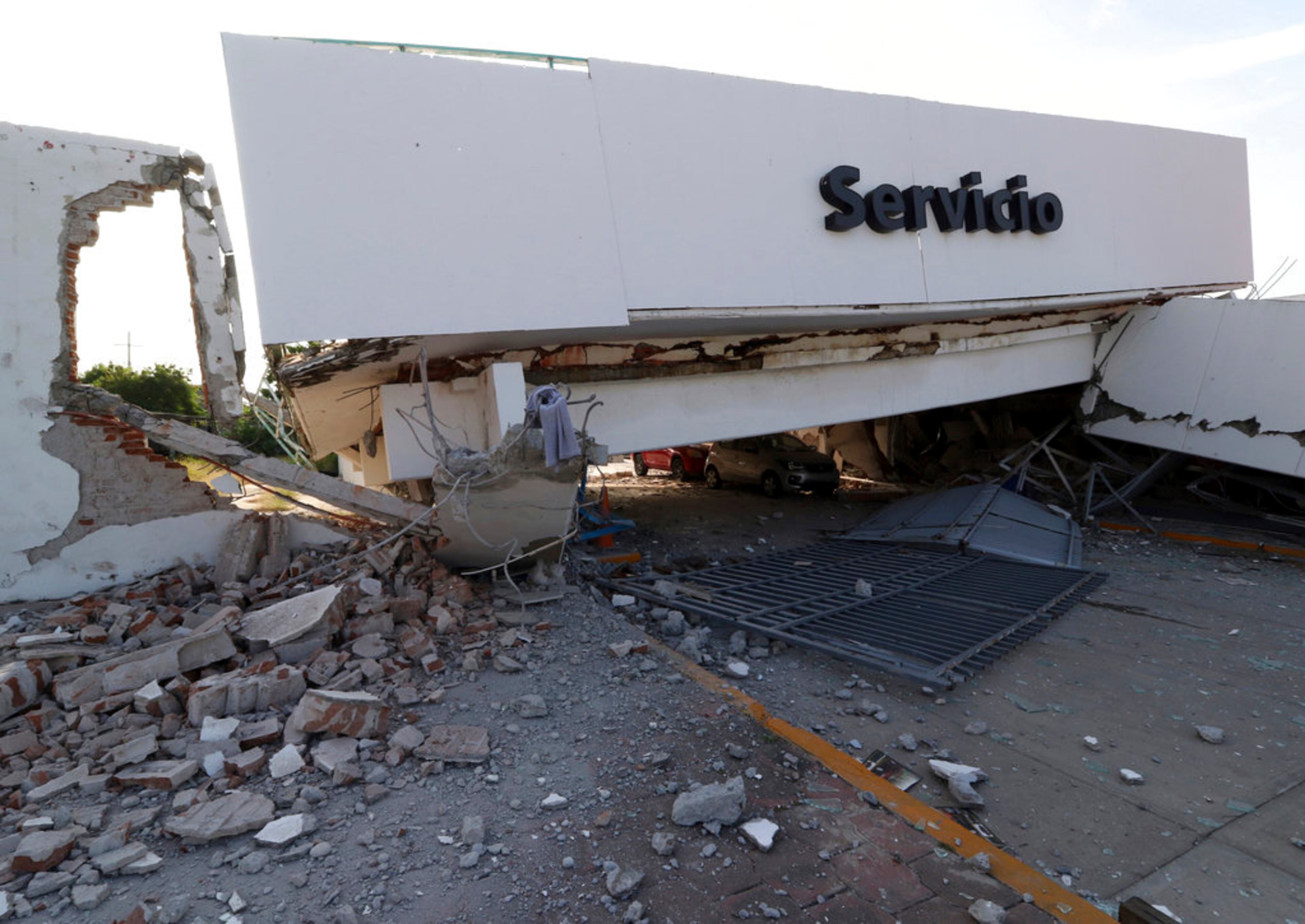 Part of collapsed building sits precariously over two parked cars in the aftermath of a massive earthquake in Juchitan, Oaxaca state, Mexico, Friday, Sept. 8, 2017. One of the most powerful earthquakes ever to strike Mexico has hit off its southern Pacific coast, killing at least 32 people, toppling houses, government offices and businesses. (AP Photo/Luis Alberto Cruz)