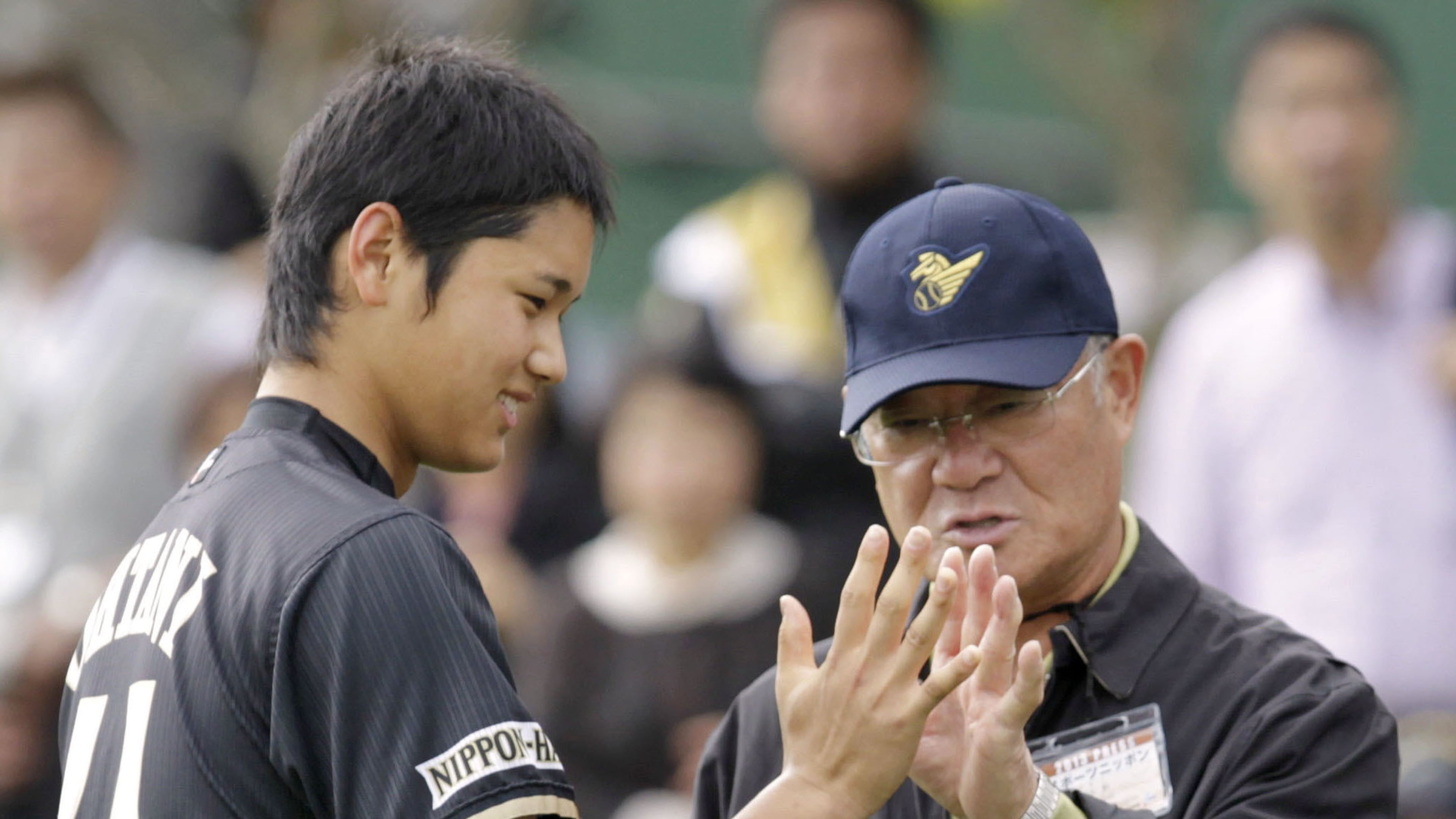 Former professional baseball player Isao Harimoto, right, compares the size of his hand with Hokkaido Nippon-Ham Fighters player Shohei Ohtani, in Kunigami, Okinawa Prefecture, Japan, Feb. 2013. (Kyodo News via AP)