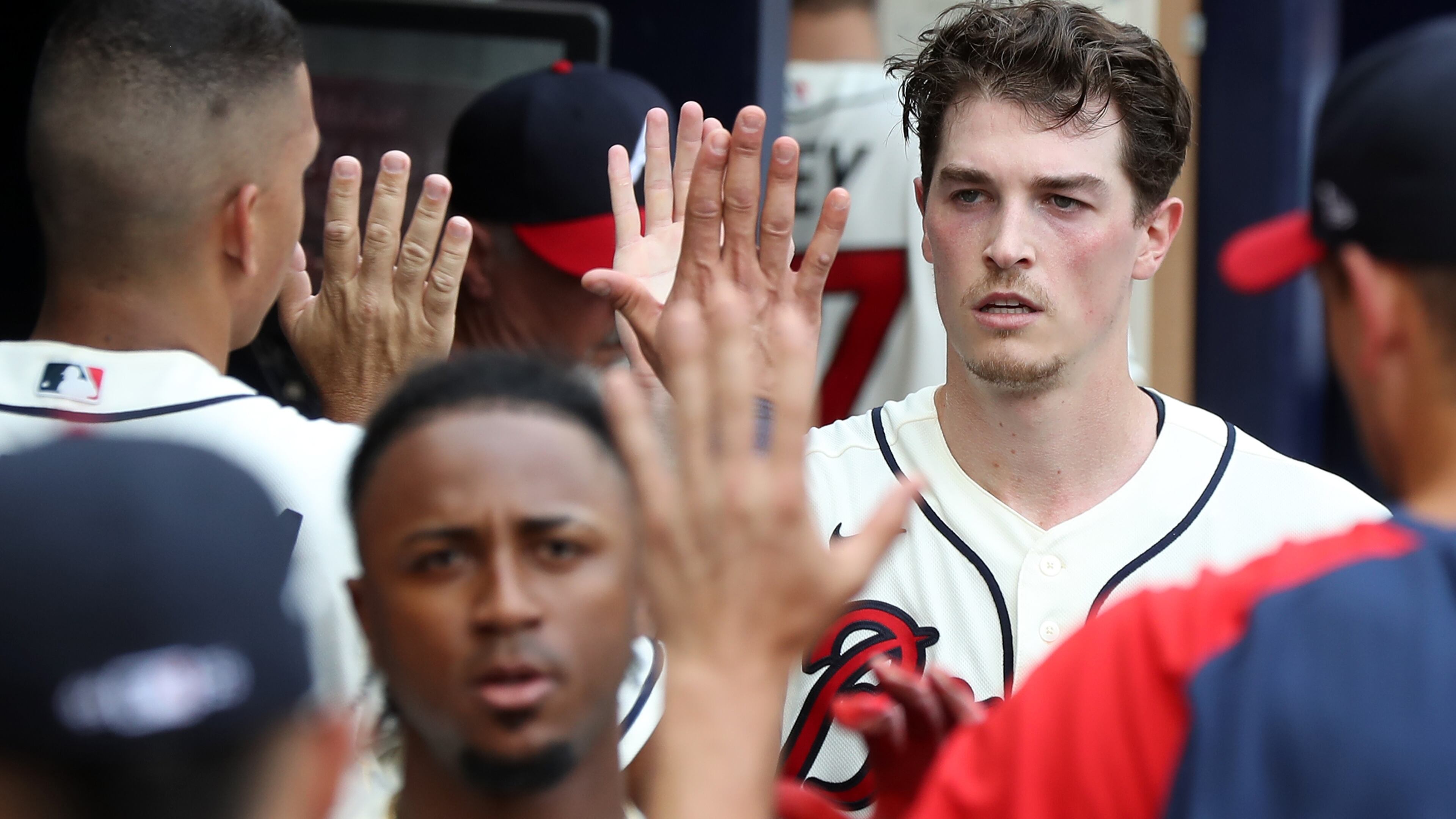 Braves pitcher Max Fried (background), who had the first hit of the day - a single - in the third inning against the Washington Nationals, and second baseman Ozzie Albies (foreground) are welcomed in the dugout following a home run by Albies that gave Atlanta a 2-0 lead Sunday, Aug. 8, 2021, at Truist Park in Atlanta. (Curtis Compton / Curtis.Compton@ajc.com)