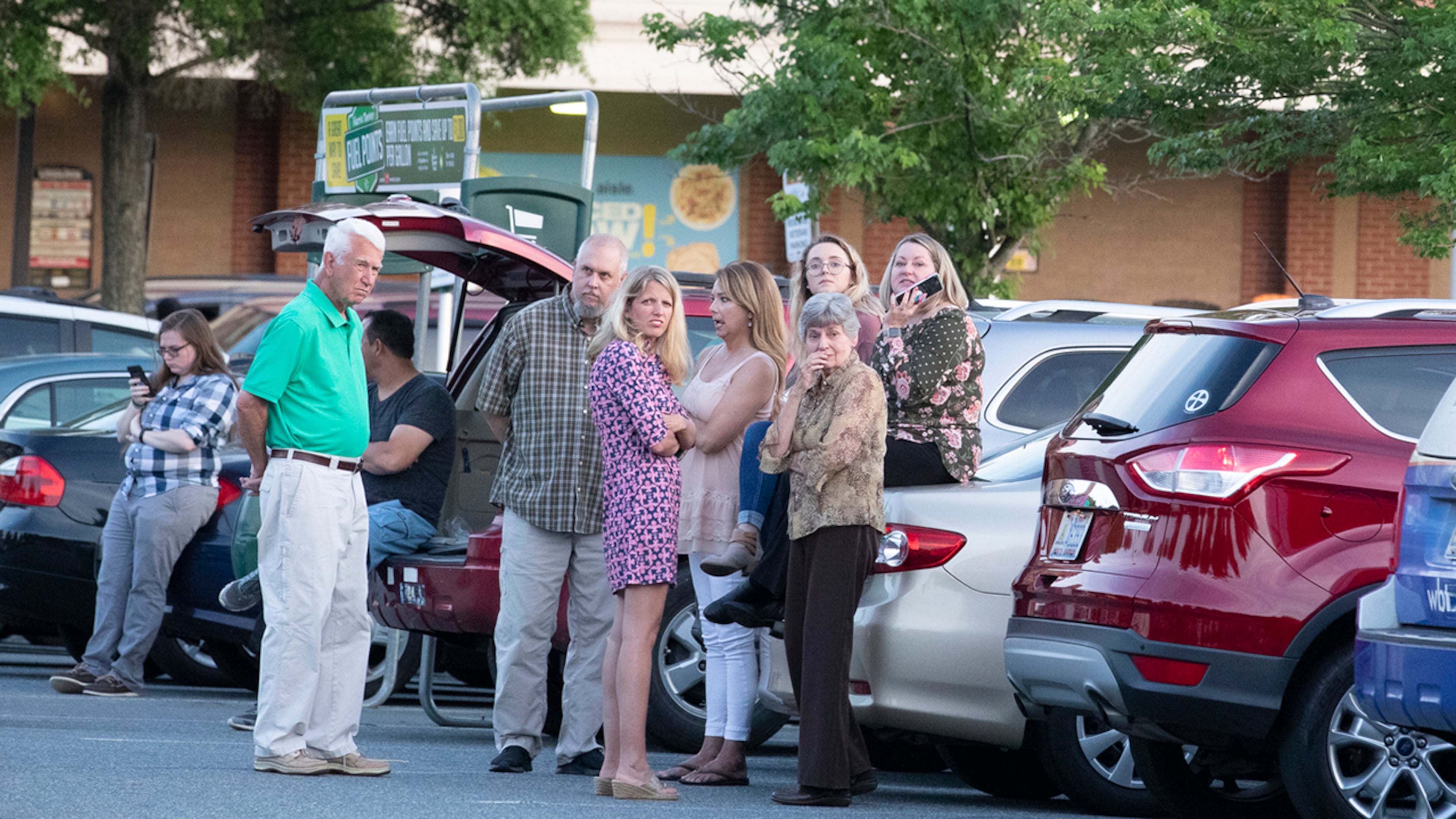 People gather across from the campus of UNC Charlotte after a shooting incident at the school Tuesday, April 30, 2019, in Charlotte, N.C., that left two people dead and four injured, three critically.