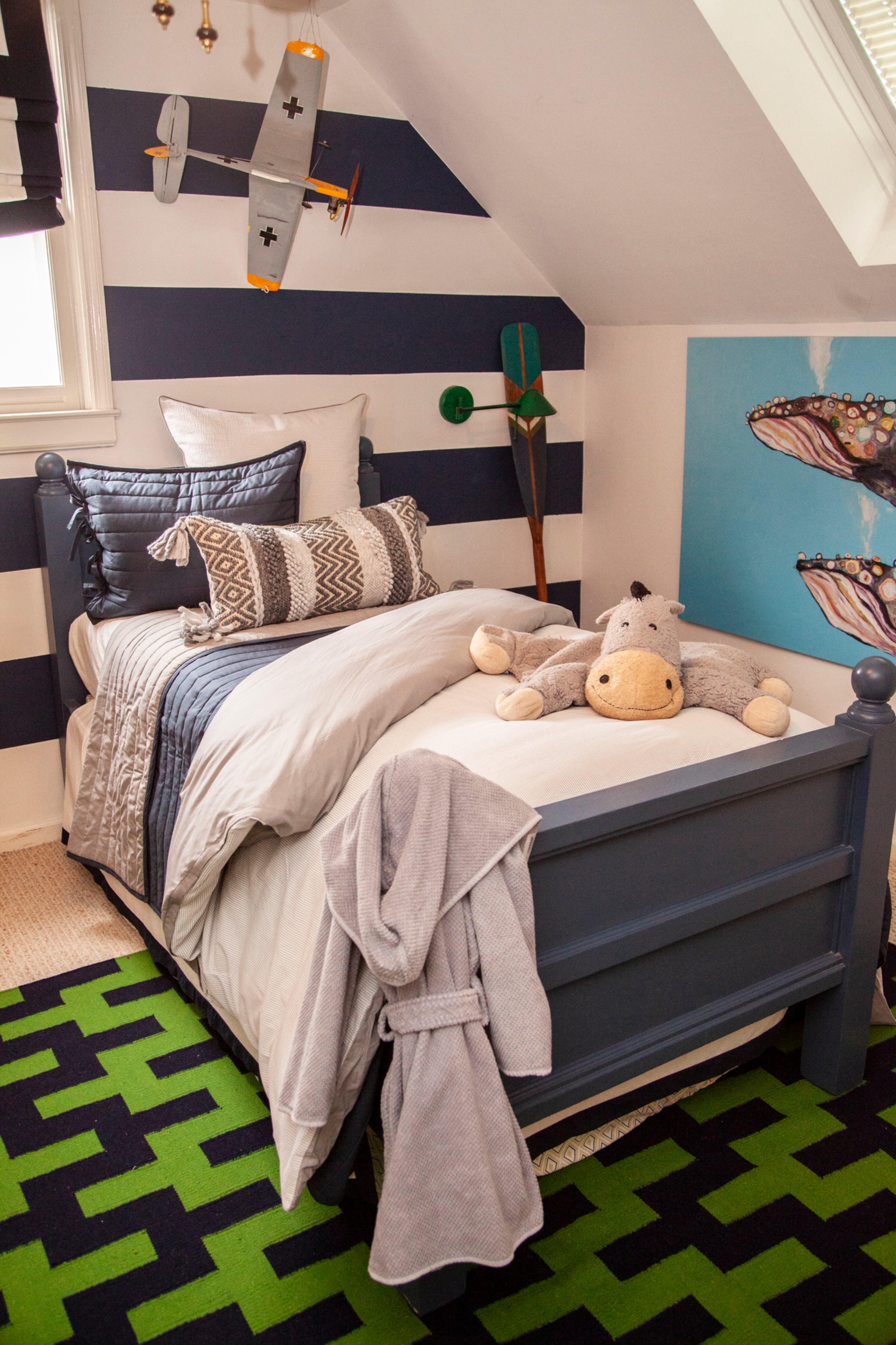 In Finnley's room, Nicole Wicking used large horizontal stripes on the walls to make the small space feel larger. The rug is from Jonathan Adler.