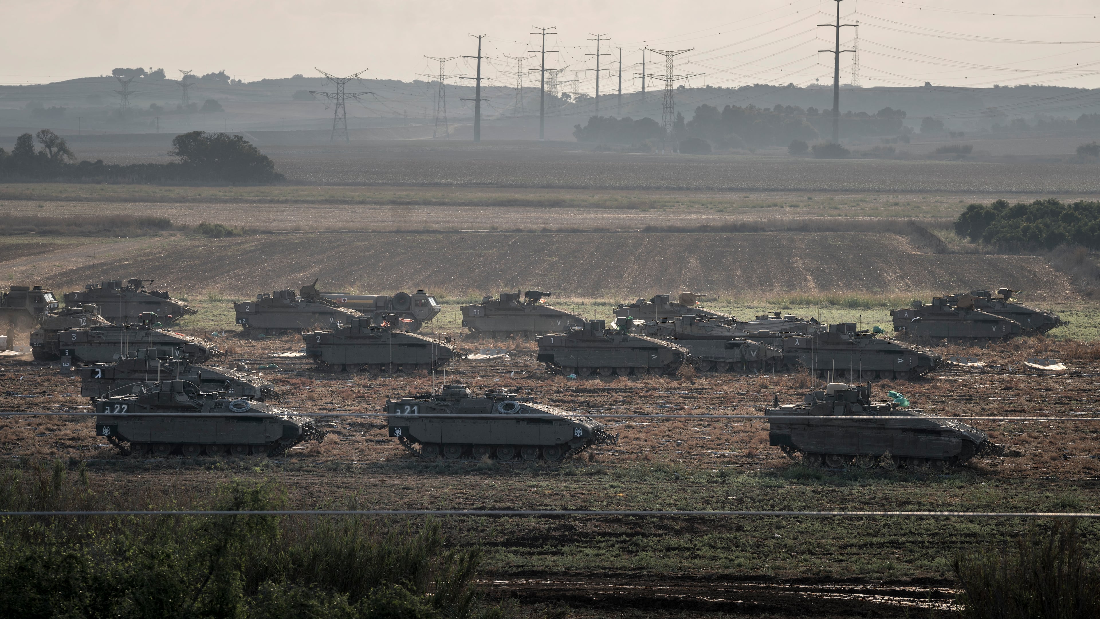 Israeli tanks on a field as they prepare to move towards the Gaza Strip, outside Erez, Israel, on Sunday, Oct. 15, 2023. (Sergey Ponomarev/The New York Times)