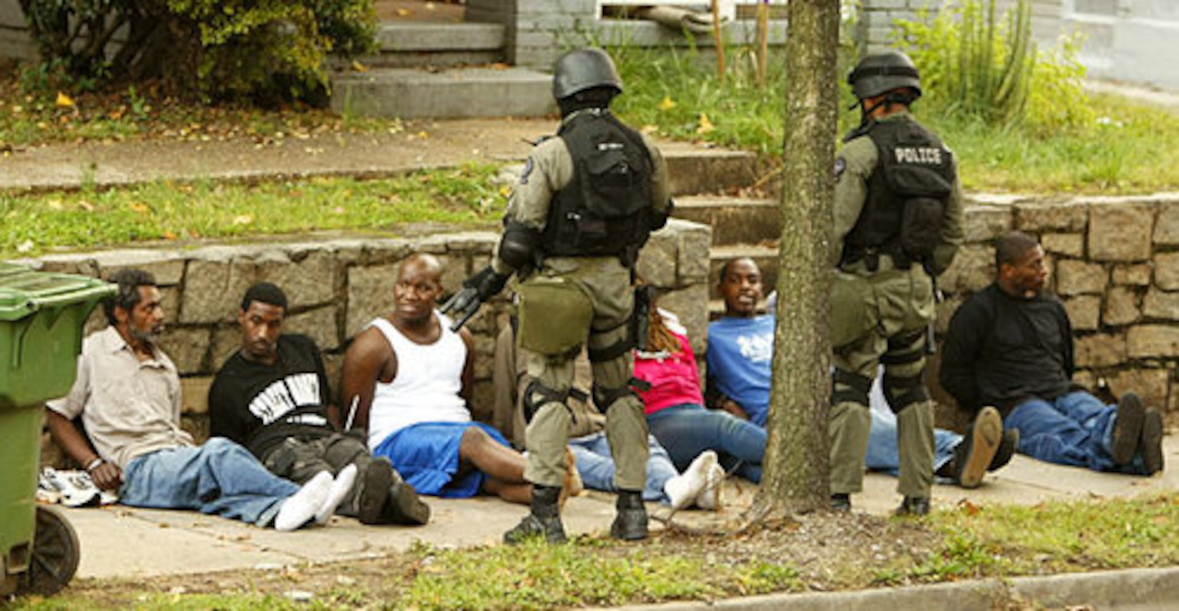 Eight people, three of them women sat on the sidewalk with their hands bound behind them at 43 Moreland waiting for a prisoner transport vehicle to take them away. On the scene was an APD explosives unit, ATF agents and US Postal Police.