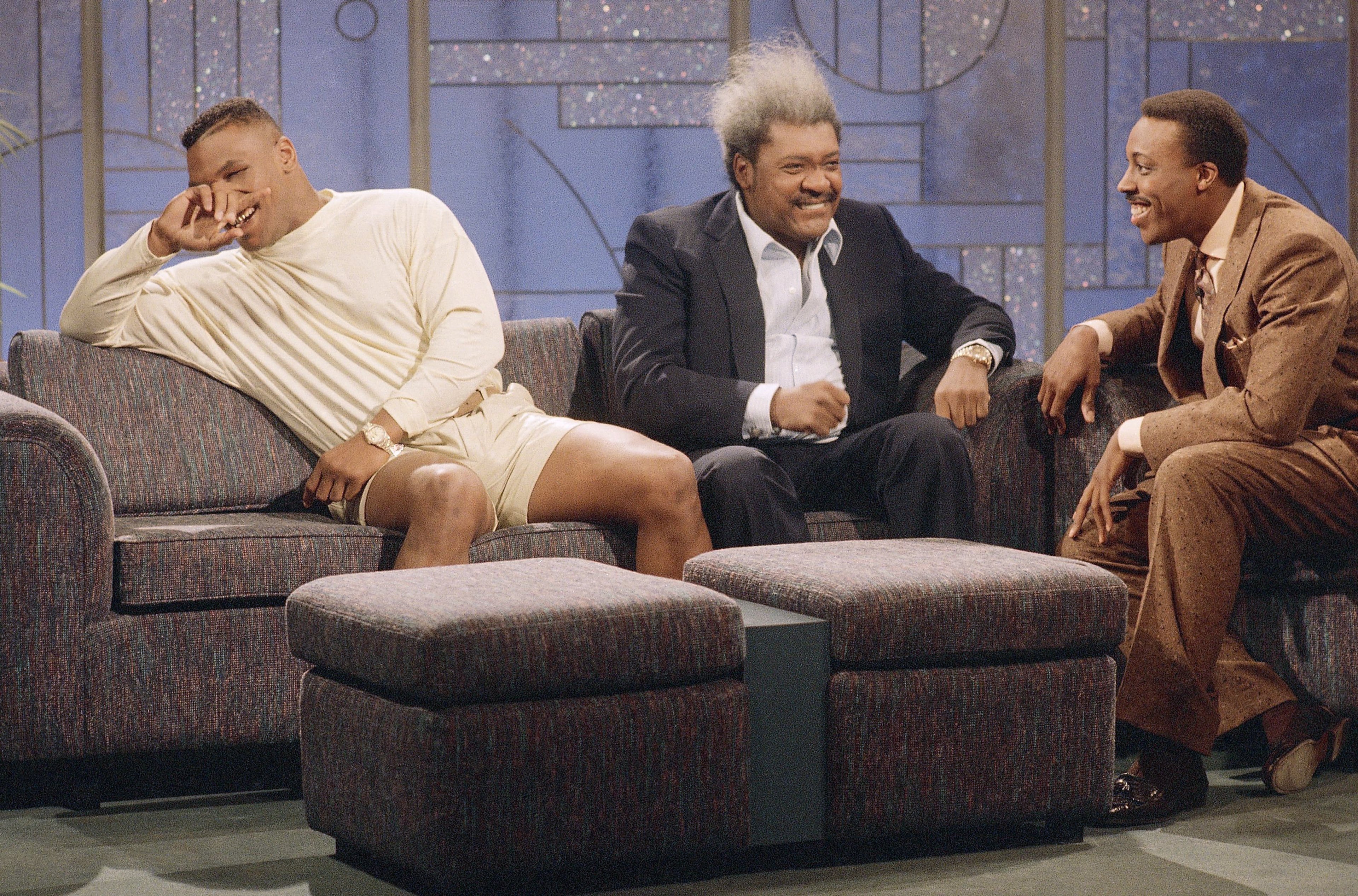 Heavyweight champion Mike Tyson and promoter Don King react to host Arsenio Hall during their appearance on the late-night talk show in Los Angeles, Tuesday, Feb. 28, 1989. Tyson broke out in laughter after Hall attempted to mimic a flurry of punches the fighter used Saturday in his defense of the world title against Britain's Frank Bruno.
