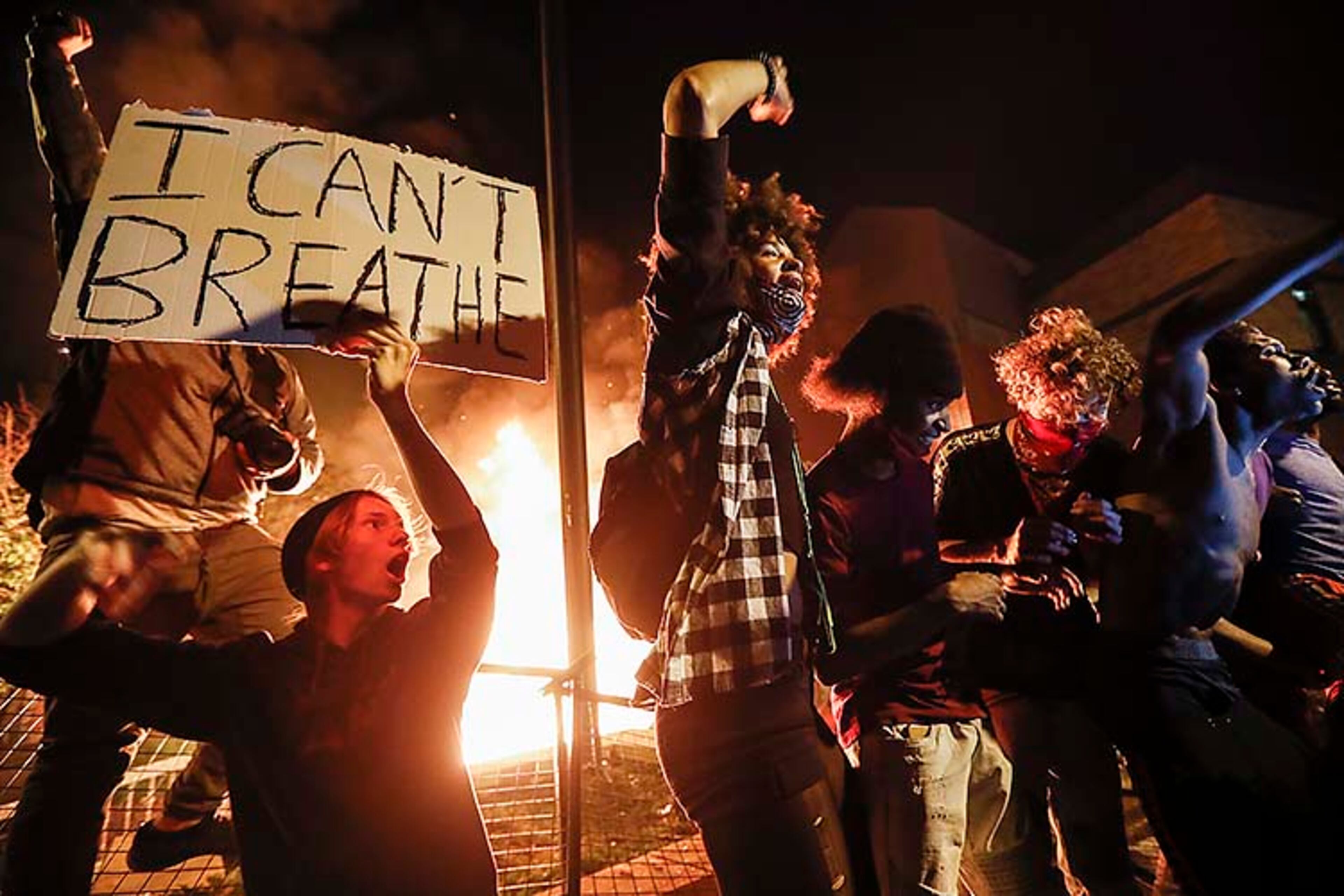 Protestors demonstrate outside of a burning Minneapolis 3rd Police Precinct, Thursday, May 28, 2020, in Minneapolis. Protests over the death of George Floyd, a black man who died in police custody Monday, broke out in Minneapolis for a third straight night. (AP Photo/John Minchillo)