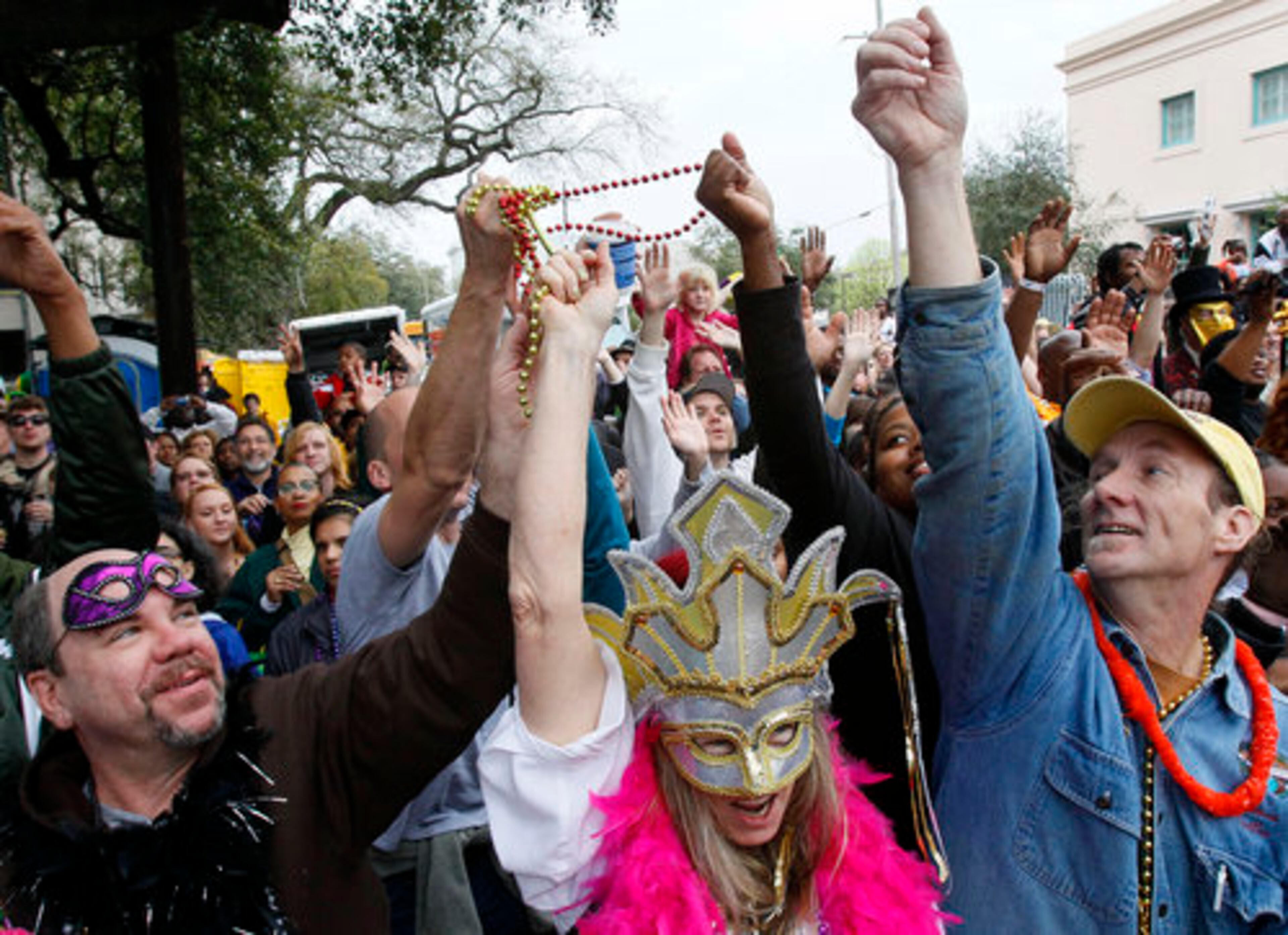 A group of revelers reach for beads tossed from a float during the Zulu Social Aid and Pleasure Club parade on St. Charles Avenue in New Orleans on Mardi Gras Day, Tuesday, March 8, 2011.