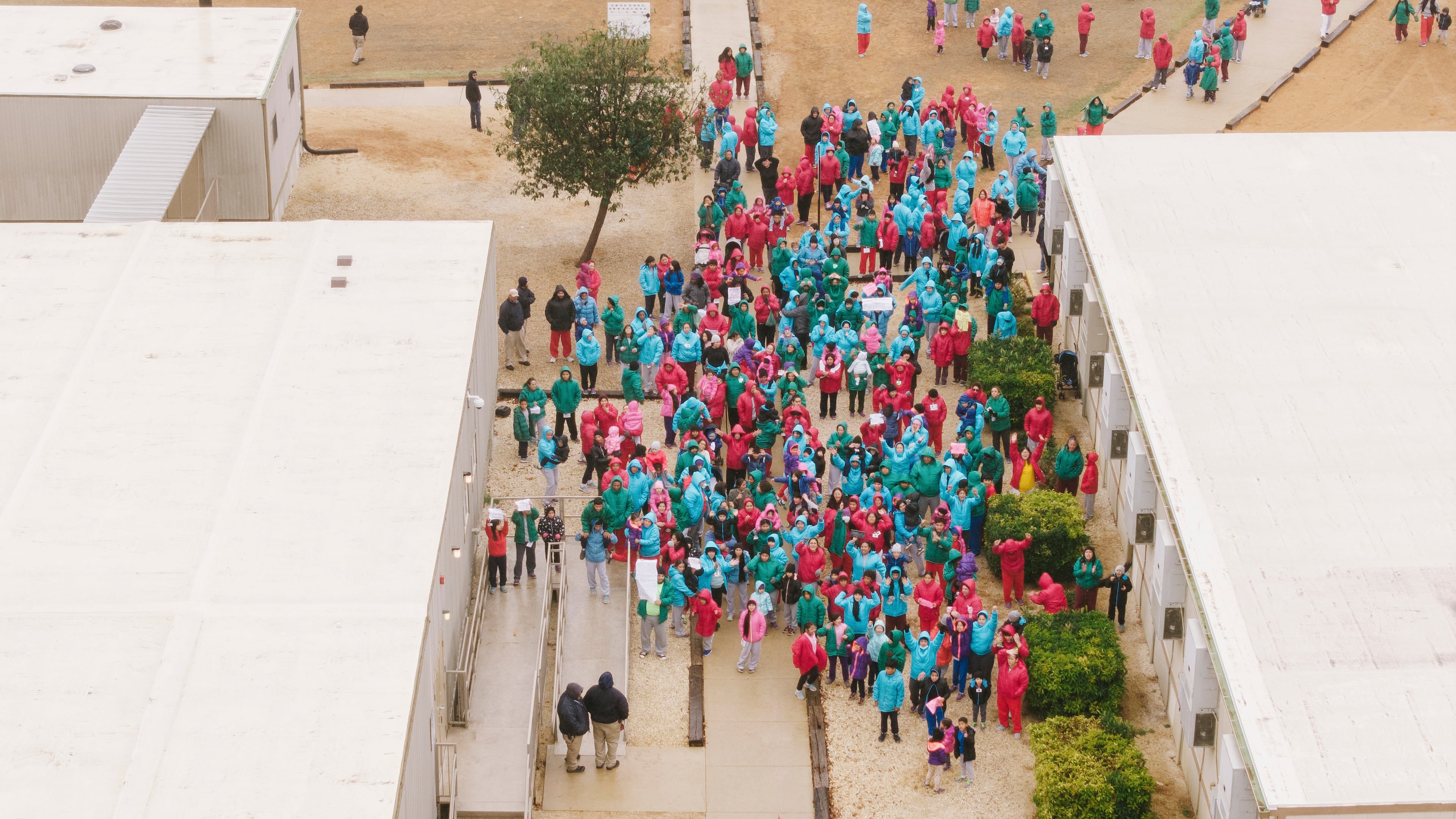 Detainees held at the South Texas Family Residential Center wave signs during a demonstration in Dilley, Texas, Saturday, Jan. 24, 2026. (AP Photo/Brenda Bazán)