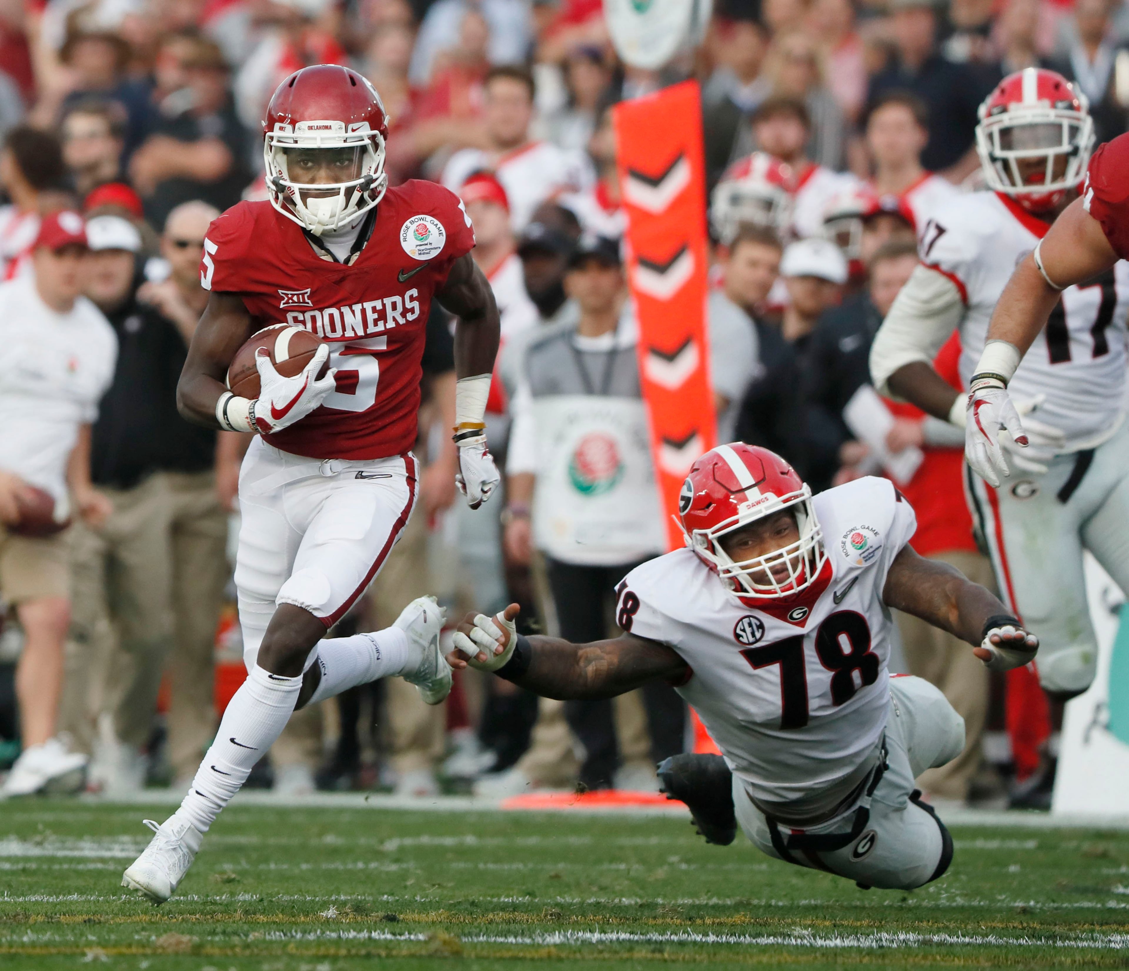 1/1/18 - Pasadena - Oklahoma Sooners wide receiver Marquise Brown (5) breaks away from Georgia Bulldogs defensive tackle Trenton Thompson (78) for a first down that helped set up Oklahoma's end of the half score at the College Football Playoff Semifinal at the Rose Bowl Game on Monday, January 1, 2018, in Pasadena. BOB ANDRES /BANDRES@AJC.COM