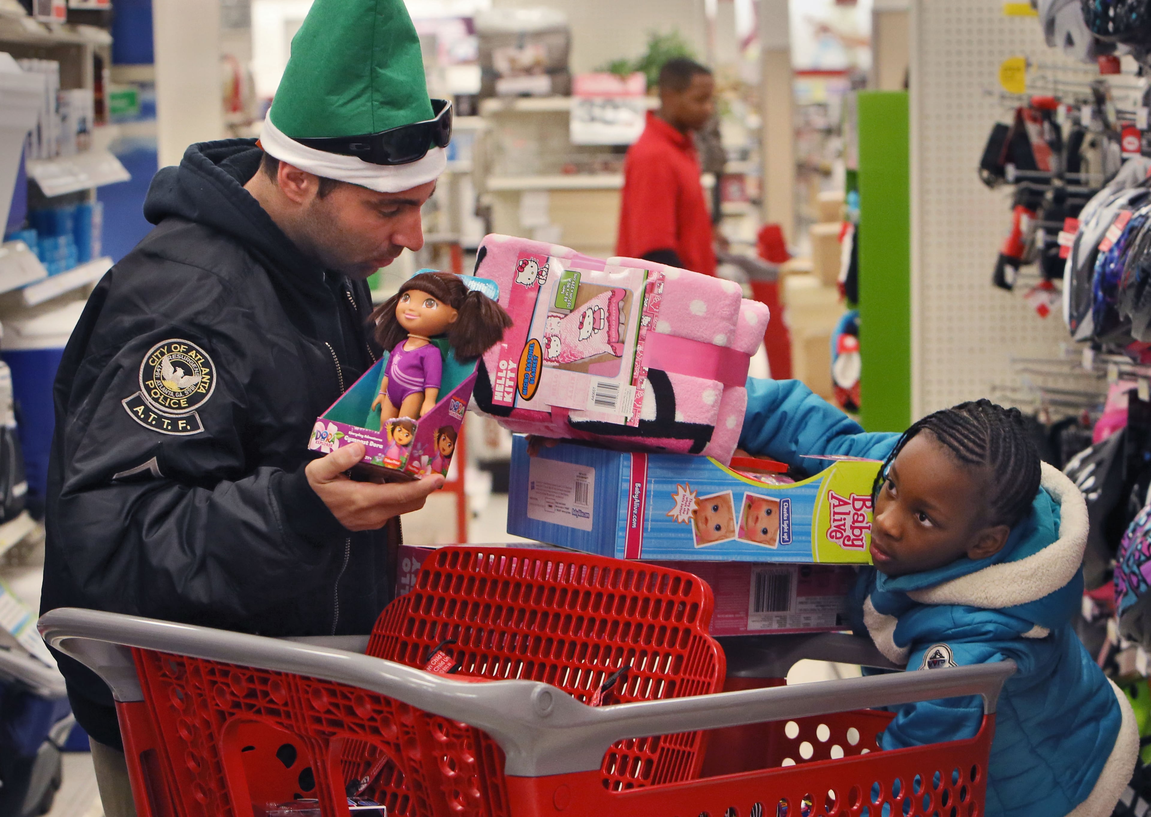 Detective Craig Fries shops for gifts with Takhia Boyd, 9. The International Brotherhood of Police Officers hosted its annual “Santa Cop” Thursday. Atlanta Police Officers and children shopped for gifts at the Atlantic Station Target store after breakfast at the Hard Rock Cafe. Most of the children involved with this event would not have a Christmas if this event were not held.
