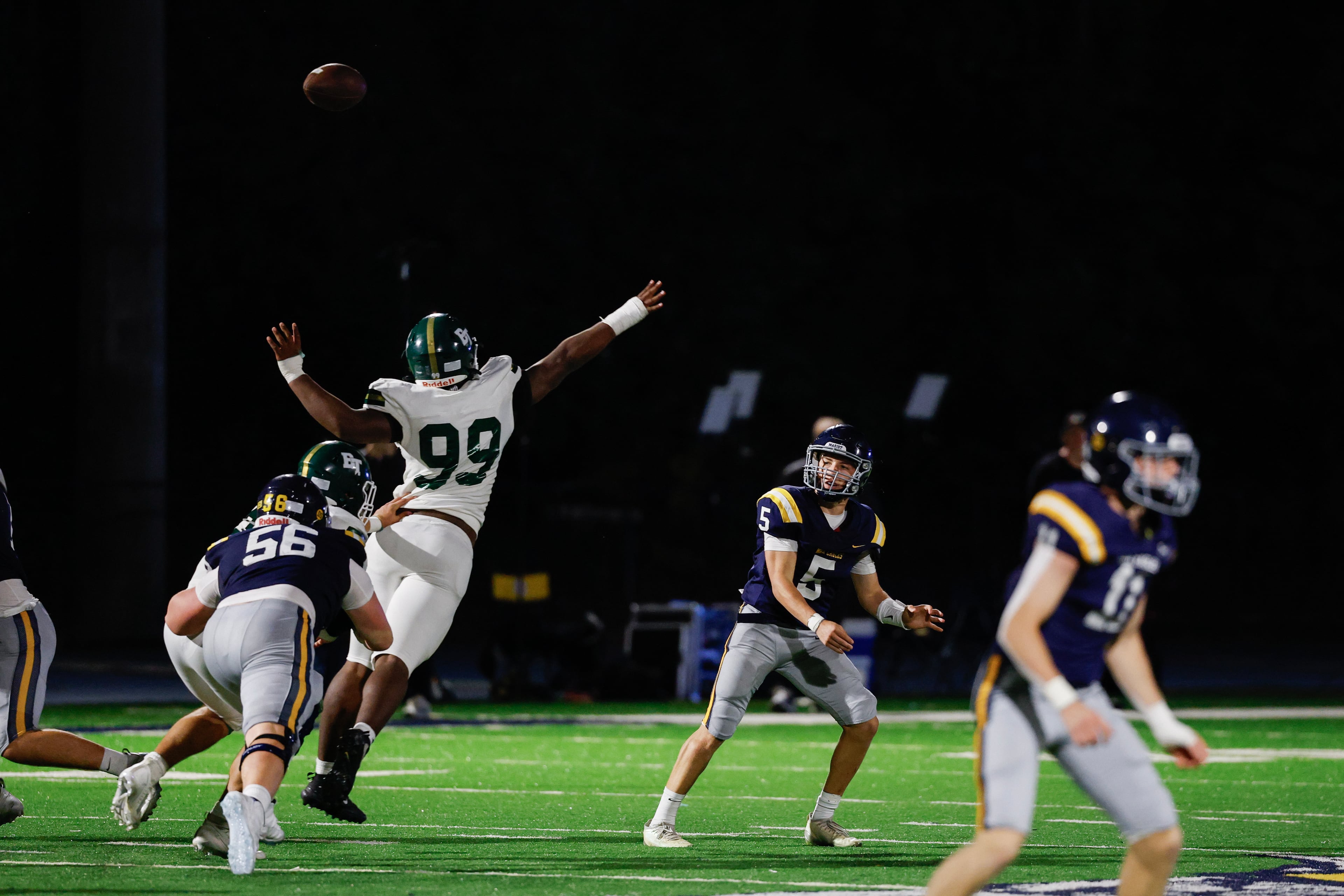 Marist’s Hayes Rollauer (back) passes under pressure from Blessed Trinity’s Dawson Jacobs during their game on Friday, Sept. 25, 2026, in Atlanta. (Erik S. Lesser for the AJC)